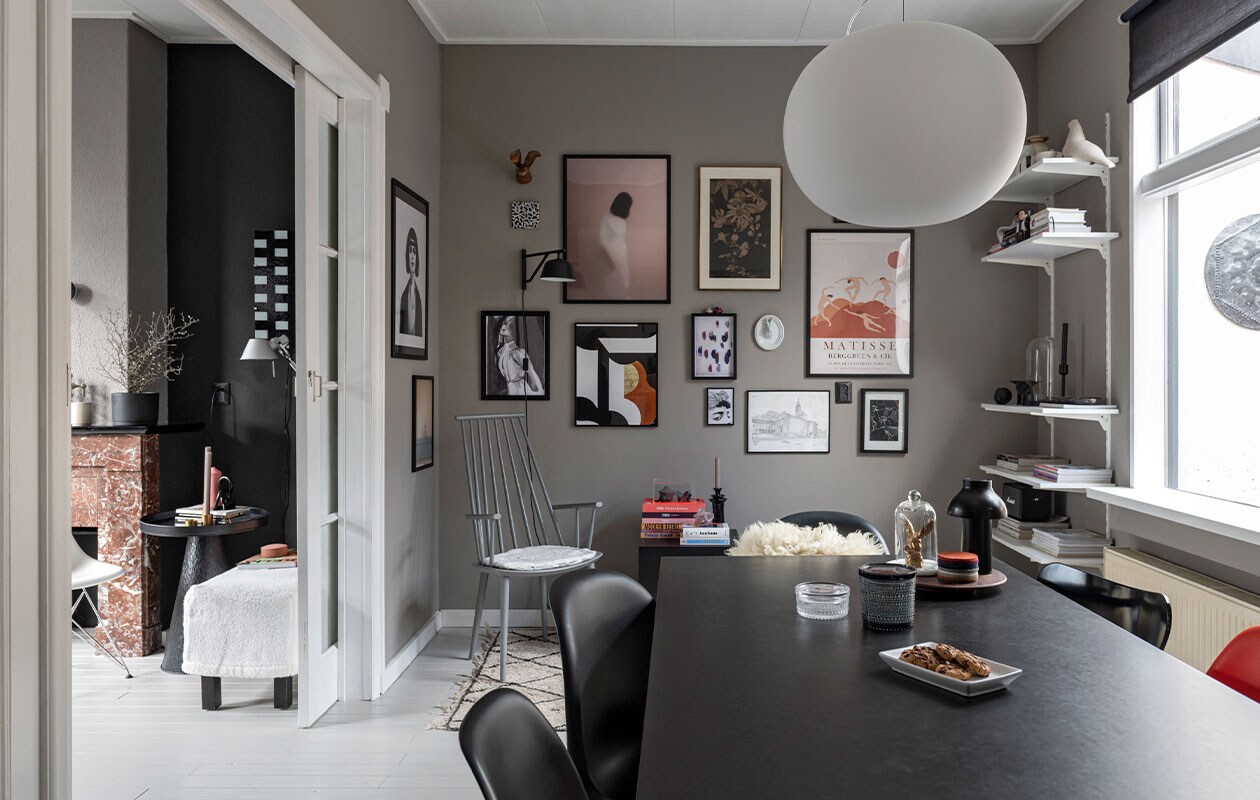 Stoel J110, wandlamp Hay, kussen zelfgemaakt. Hanglamp Glo Ball S2 van Flos. Vloerkleed en vitrinekist HKliving, minivaasjes Hella Duijs. Zwarte bijzetter Westwing, kandelaar Day. Konijn Vintage Fever, onderzetters Nio &amp; Elva. Potten Iittala. Wandlamp Ambit van Muuto. Kunst v.l.n.r.: print vrouw Mia Wallace via Ruben Ireland, H&amp;M. Haas papier-maché Babettes Wereld, tegel Studio Job van Koninklijke Tichelaar, posters vrouw en print druppel en gezicht Juniqe. Minivaasjes op lijst van bevriende kunstenaar. Print roze vrouw Gurille Design, grafische print Part 2 Terra van Atelier Andrea. Passiebloem van Anton Pieck uit ouderlijk huis. Keramieken hazenkop Des Pots. Print Matisse Pstr studio. Tekening Zwitserse kerk door plaatselijke kunstenaar. Print Rechtszaak van Studio Abeelen. Muurverf Authentic Grey van Flexa. Eettafel en zwarte lamp Hay,. Konijn Vintage Fever. Panton Chairs van Vitra, vacht sheepy.cc.