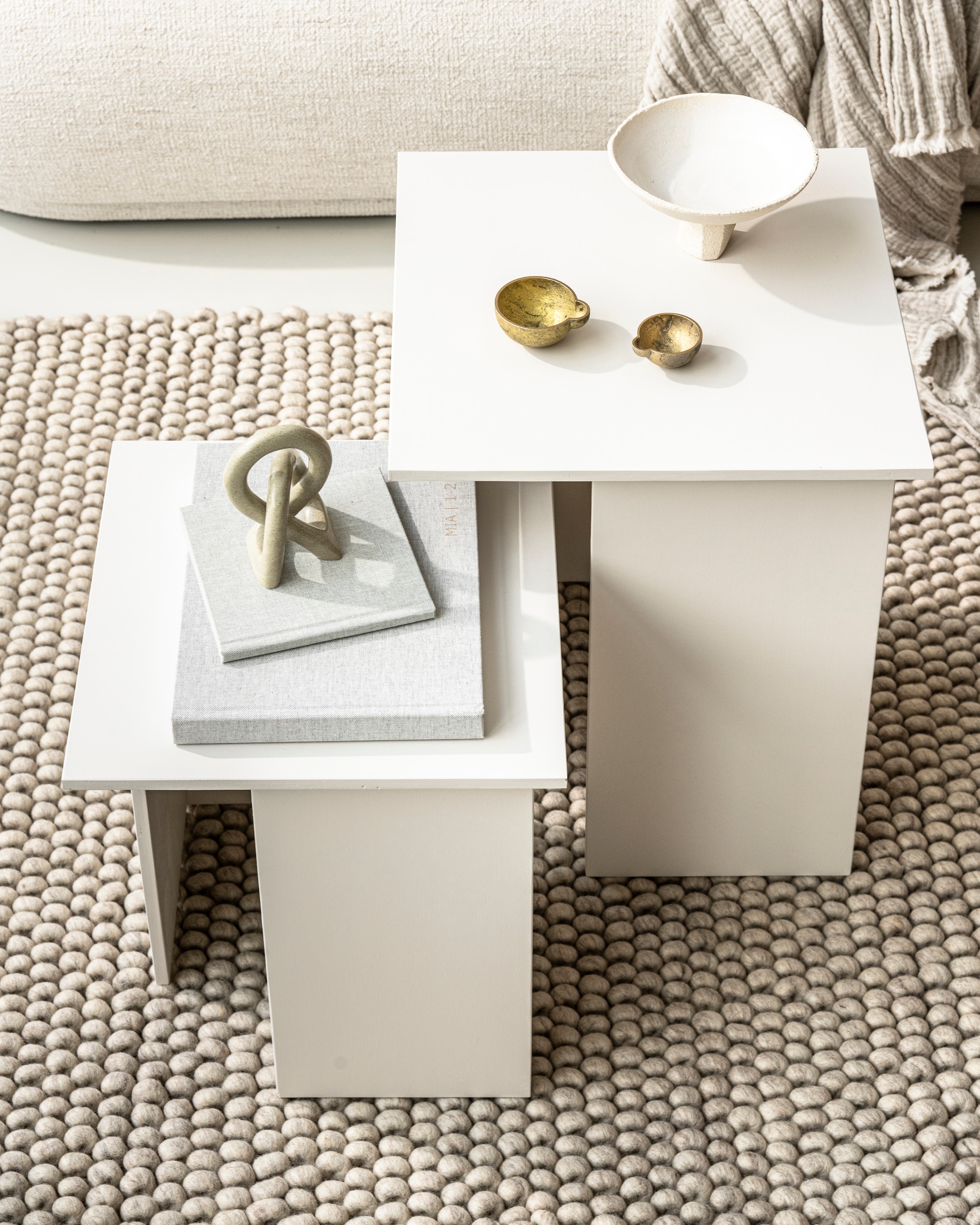 Bouclé driezitsbank Rico van Ferm Living € 2985,-. Wollen vloerkleed Peas van Hay, 200×300 cm € 999,-. Witte schaal Rock Vessel van Marlies Huybs € 130,-. Spekstenen object Kisii S € 25,-, rechthoekig kussen van Marleen van Haaften in samenwerking met Studio Yen € 75,-, messing olielampjes van Casegoods, set € 30,- (studio-yen.com). Kussen Moroccan stripe € 105,- (billierose.be). Overig privébezit.