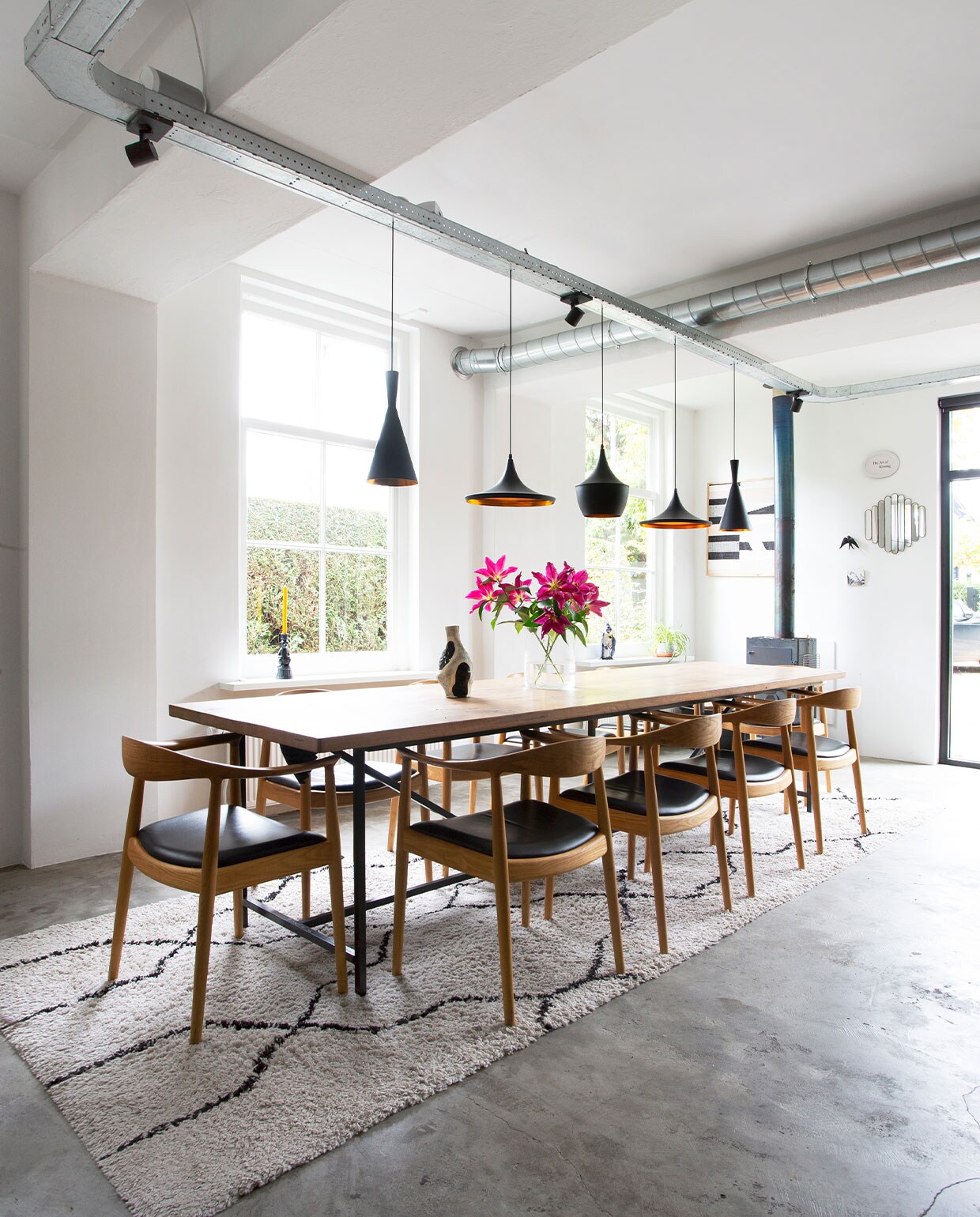 Tafel Jan van IJken. Stoelen Kennedy Chairs van Hans Wegner. Hanglampen Tom Dixon. Pizzaoven Weltevree. Vloerkleed Karwei. Spiegels Sissy-Boy Homeland. Vazen onbekend.