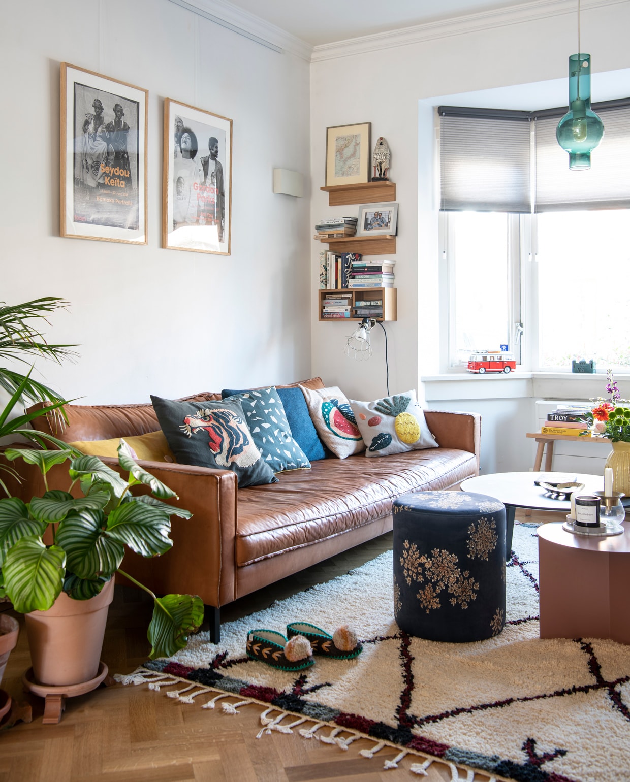 Bank Loods 5. Kussens: gele en blauwe Dot van Hay, met tijger- en meloenprint Sissy-Boy, met grafisch dessin Ferm Living, met ananasprint &amp;klevering. Vloerkleed The Weavery Shop, poef Essenza Home. Bijzettafel Slit en salontafel CPH Deux 250 van Hay. Geurkaars Bibliothèque van Byredo via Skins Cosmetics. Hanglamp Felice home of brands, raambekleding van Luxaflex via Vonk &amp; Vloer. Boekenplanken Muji, klemspot Merci Parijs. Ingelijste prints aan de muur Foam. Slippers Give a pom. Beeld vogel souvenir uit Nigeria van Lindsays vader, ernaast een ingelijste plattegrond van Etsy. Wandlamp hing al in het huis, bank in erker van Hay voor Ikea.