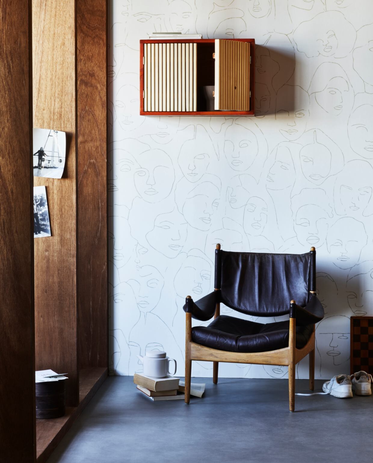 Vintage interieur: zwarte fauteuil met houten hangkast.