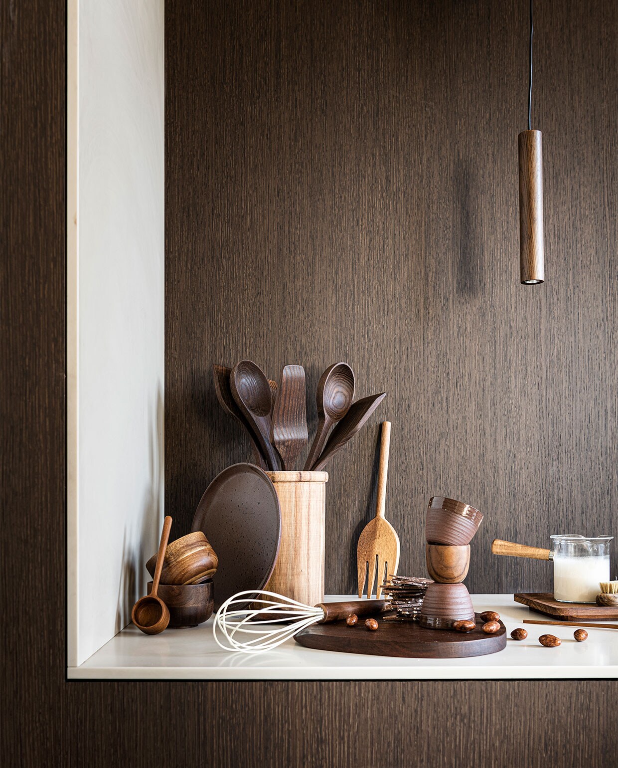 Panelen met behang met houtprint Essences de bois – RM 430 75 van Elitis, per meter € 135,- (loggerewilpower). Houten mokken van Serax € 13,60, houten keukengerei van Serax, set van 5 € 53,-, houten hanglamp van Umage € 75,-, rechthoekig houten bord van Serax € 25,- (vtwonen). Rond bruin bord € 22,90, bruine espresso mokken, per stuk € 6,90 (letoile.store). Houten pot € 29,99, houten koffielepel € 9,99, houten garde € 11,98, houten vork uit slacouvert € 17,99, melkkan met houten handvat € 15,99 (zarahome). Houten eierdop, per stuk € 3,99 (sissy-boy). Overig privébezit.