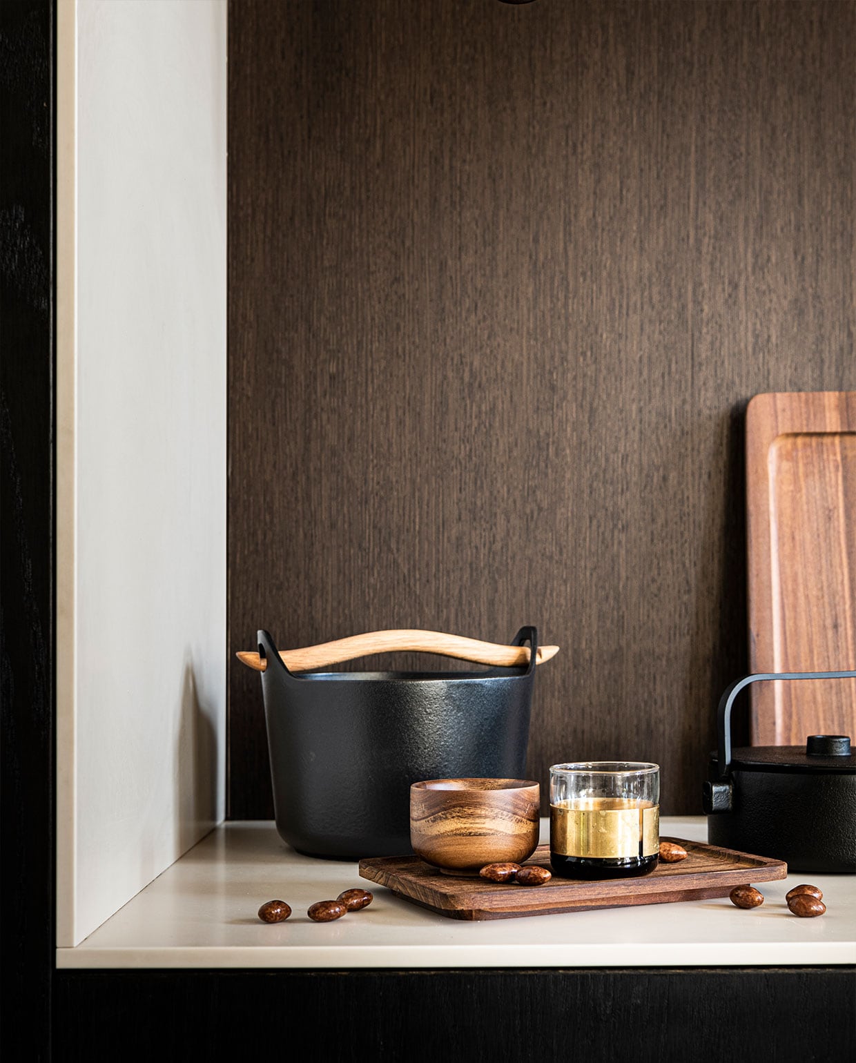Gietijzeren pan met houten handvat van Iitalla € 92,-, rechthoekige borden van hout in twee maten, van Serax per stuk vanaf € 25,-, houten mok van Serax € 13,60, glas met messing band van Serax € 17,99, gietijzeren theepot van Serax € 92,- (vtwonen.be).