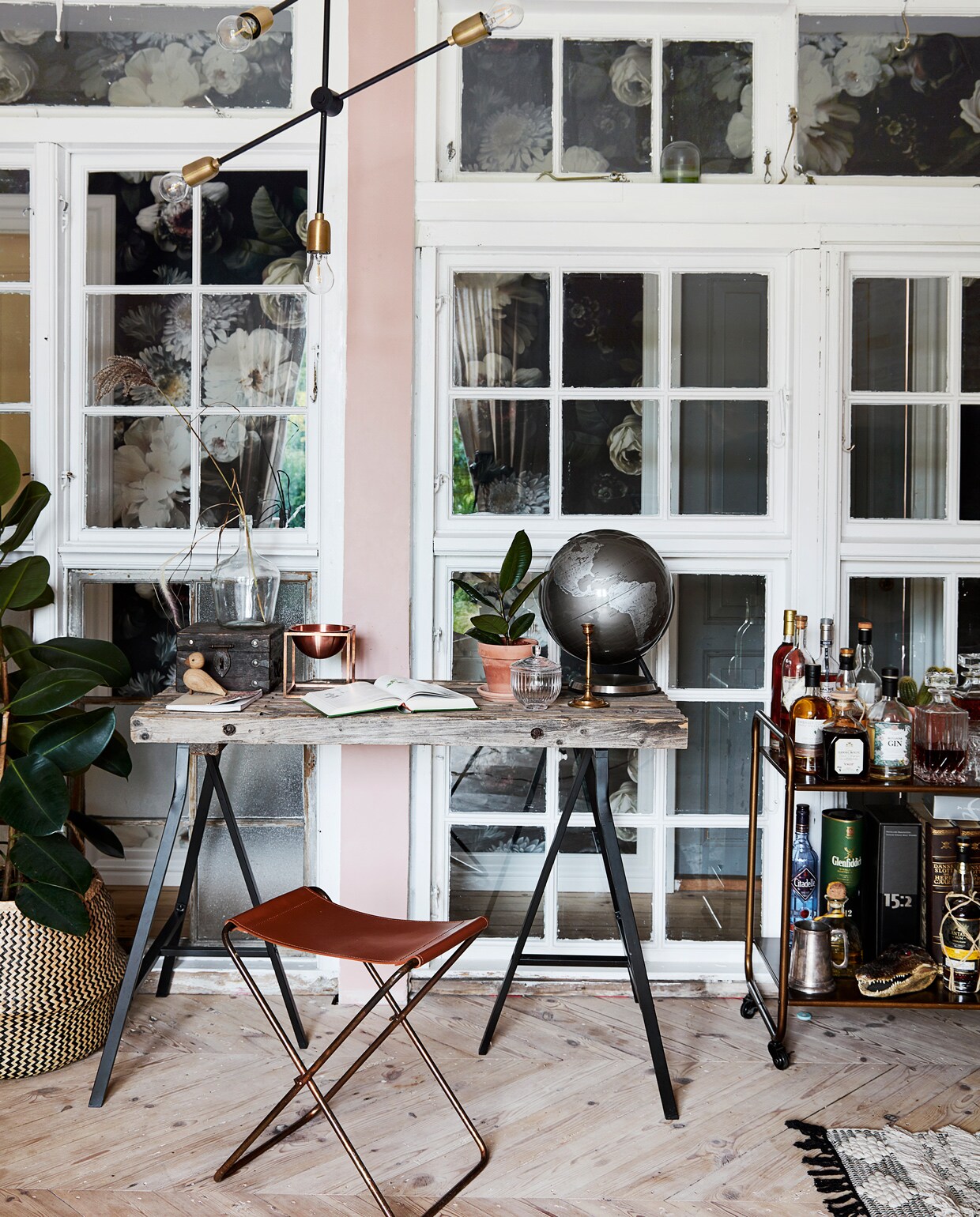 Wand naar de hal vintage ramen Genbyg. Bloemenbehang Ellie Cashman. Bureau van Ikea-schragen met vintage blad. Kruk Broste Copenhagen. Lamp House Doctor. Serveerwagen vintage.