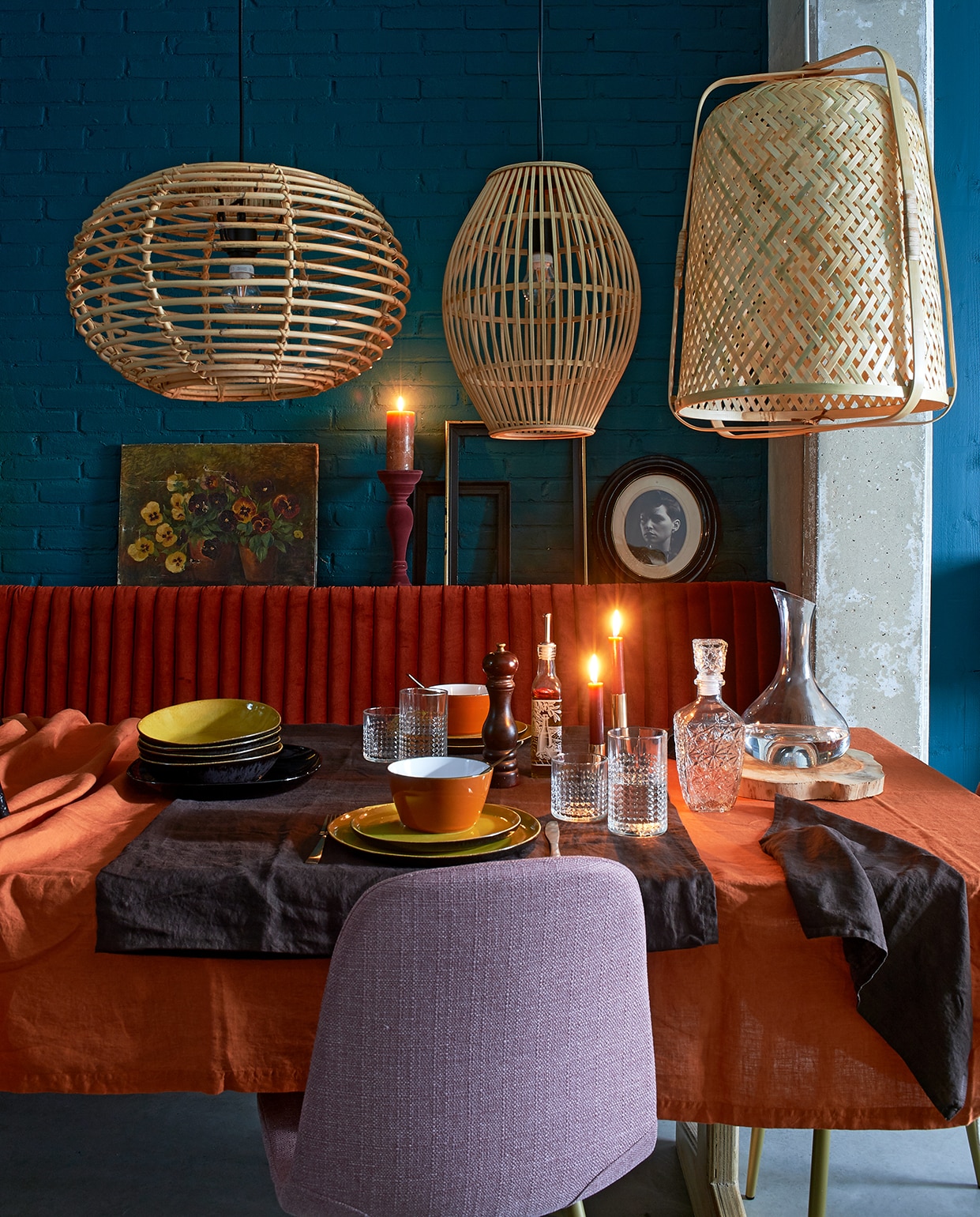 Lampen boven tafel, v.l.n.r. hanglampA ilene€ 49,95, ovale bamboe hanglamp € 34,99, bamboe hanglamp Knixhult€ 39,95 (ikea). Linnen tafelkleden, 145 x 250 cm à € 39,99, linnen servetten, 45 x 45 cm € 9,99 per 2, goudkleurige kandelaar laag € 7,99, hoog € 9,99. GlasFrasera, laag € 1,99, hoog € 2,49, karaf Storsint€ 7,99 (ikea). Mosterdgeel servies Krisha, 12-delig€ 119,- (made.com). Steenrode kom Glossy € 2,99, rode velvet kaarshouder € 6,50, kaars € 0,99.