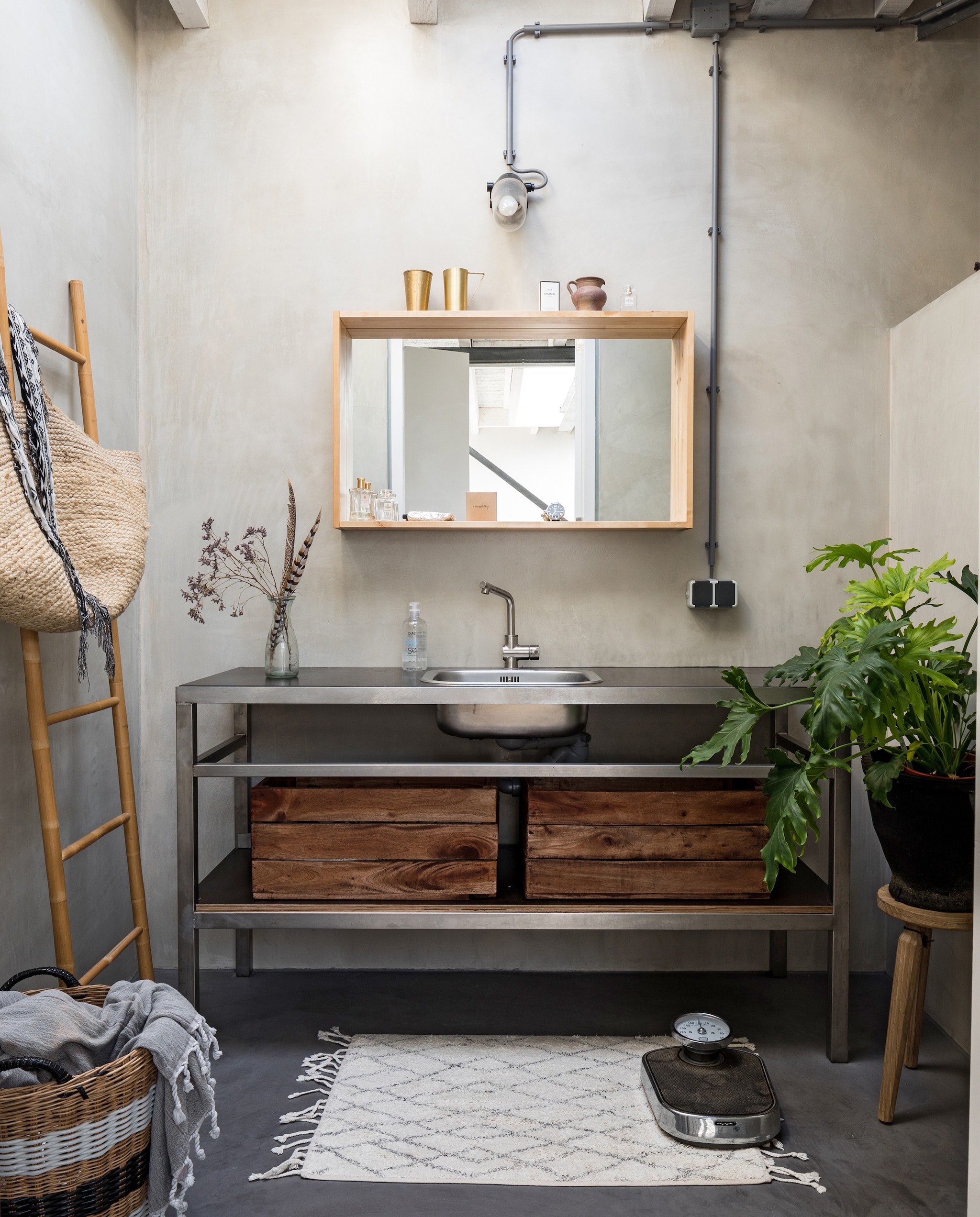 In de badkamer werden alle wanden en de vloer behandeld met beton ciré. De spiegel is van Ikea, het wastafelmeubel is op maat gemaakt van rvs. Houten kistjes van Xenos. Badmat HK Living, weegschaal Dille &amp; Kamille, ladder Hübsch. Oude mand van Mariekes moeder gekregen, hamamdoek en tas van grooothandel Tica. Photo: Hans Mossel