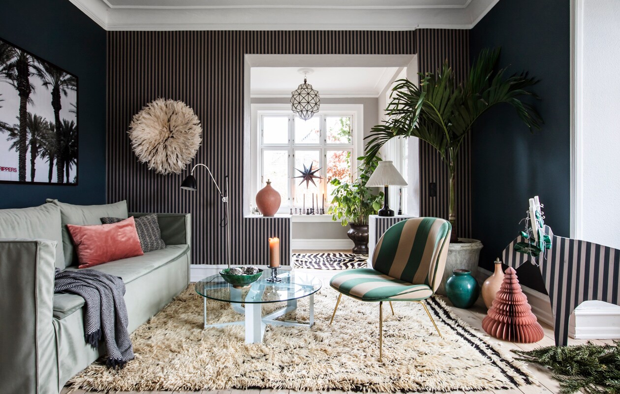 Behang met streep en monochroom Farrow &amp; Ball. Stoel en vloerlamp Gubi. Witte tafellamp erfstuk. Fotokunst The Wall Market. Overig herkomst onbekend.