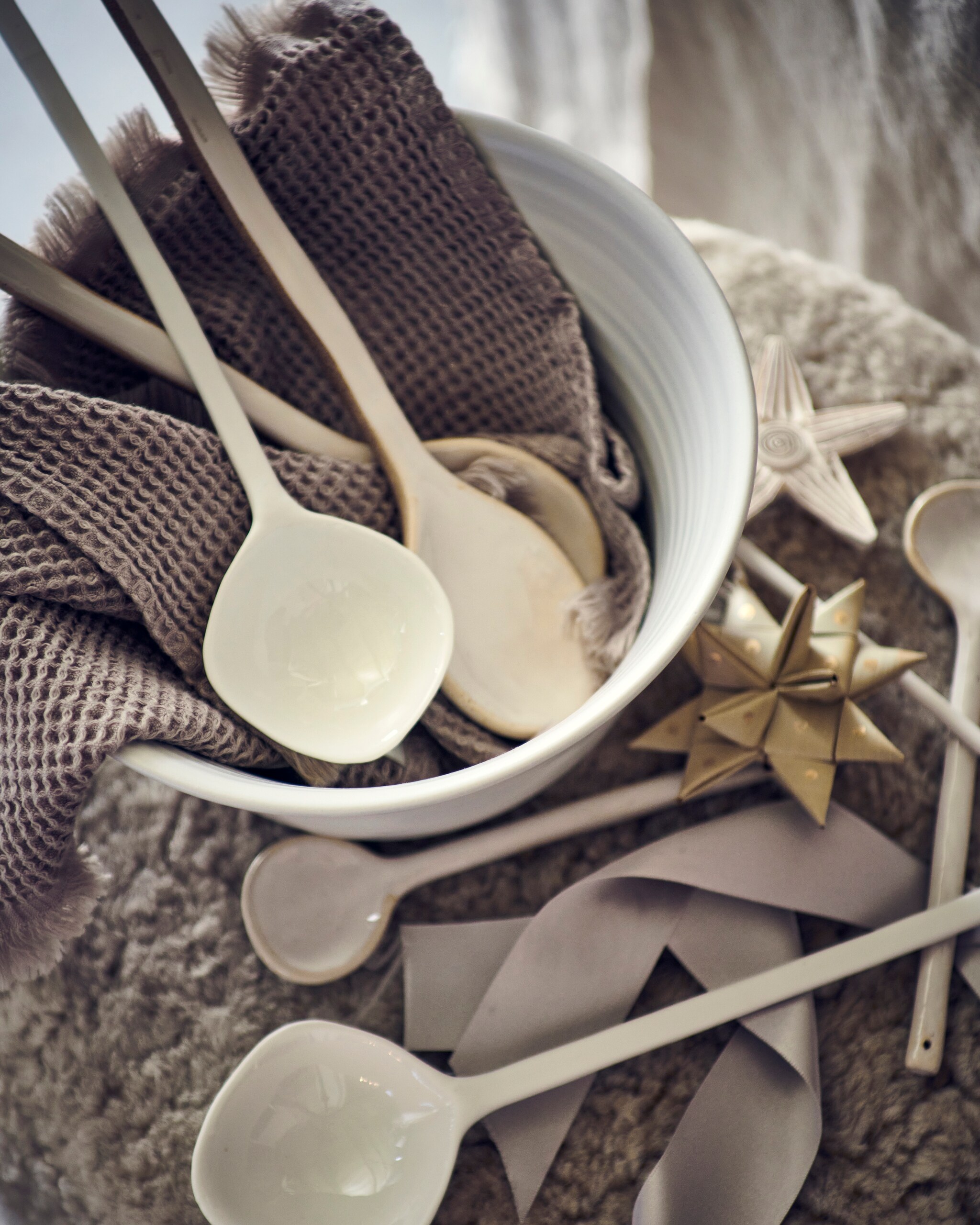 bouclé kruk van Menu (designtales.nl). Witte schaal van Studio Ro Smit (factor-ij.amsterdam). Grijze wafeldoek € 7,99 (h&amp;m). Witte porseleinen lepels, per stuk vanaf, beige papieren ster met gouden stippen, set van 3, witte papieren ster (letoile.store). Beige keramieken lepels, per stuk vanaf € 4,99 (sissy-boy).