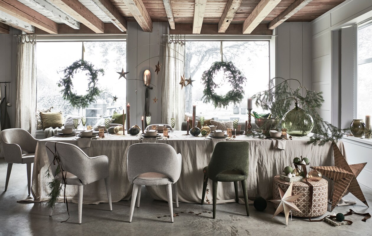 Takken en kransen, prijs op aanvraag (tuinvanjudith.wordpress). Om de tafel: linnen schort € 24,99, linnen gordijnen, set van 2 € 69,99, gouden etagère € 19,99 (hm.com). Groen linnen schort € 30,- (paviljoennoord). Beige gestoffeerde stoelen van Pols Potten, per stuk € 425,- (vtwonen). Groen gestoffeerde stoel € 355,- (polspotten). Poef met print, prijs op aanvraag (vantil.nl). Eetkamerbank van Menu (designtales). Bladeren gemaakt van kralen (letoile.store). Gouden wandkandelaar € 40,-, papieren ster € 17,-, dozen van decoratief papier, set van 2 € 17,- (bungalow). Gouden metalen slinger van sterren € 22,95 (weldaad). Groene stoffen kerstballen, per stuk vanaf € 5,50 (nordal). Vintage okergele metalen ster (pietjonke). Interieurontwerp Piet-Jan van den Kommer (vandenkommer). Op en boven tafel: linnen tafelkleden, per stuk € 39,99, servetten, per set van 2 € 9,99 (h&amp;m). Groene borden, per stuk € 27,95, beige kommen, per stuk vanaf € 13,95, groene ovalen borden, per stuk, alles aardewerk van Studio Ro Smit (factor-ij.amsterdam). Beige borden, per stuk € 25,- (nordal). Groene champagneglazen, set van 6 € 160,- (polspotten). Okergele waterglazen, per stuk € 7,50, gouden bestek, per stuk vanaf € 6,95, okergele glazen XL kerstballen, per stuk € 24,50, gouden kandelaar voor blokkaars € 50,-, groene glazen bolvaas € 70,- (paviljoennoord). Gouden mini-kandelaar, kaarssteker in vorm van aureool (letoile.store). Gouden kandelaar in vorm van ster € 4,50 (weldaad). Smalle hoge blokkaarsen, per stuk vanaf € 15,- (allestedlund). Antiek zilveren wijnkoeler (pietjonker). Gouden mobile met sterren € 59,99 (sissy-boy). In de vensterbanken: kussens met decoratieve groene print, per stuk vanaf € 42,50, groen fluwelen kussen € 30,-grijs fluwelen kussen € 30,-, groene papieren ster € 8,- (bungalow.dk). Mohair plaid € 99,99, beige bouclé kussen € 22,99 (zarahome). Velours kussen in groen, okergeel en grijs (wva). Groene keramieken pot € 24,99 (h&amp;m). Groene blokkaars € 25,50 (allestedlund).