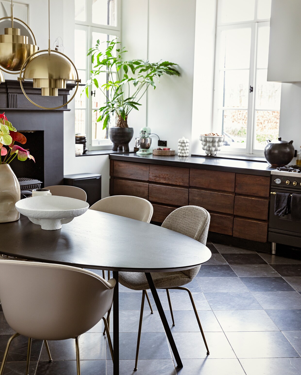 Tafel Studio Henk. Plafondlampen en stoelen Bat en Beetle van Gubi via Interior Playground. Schaal Serax. Kaars l’Objet. Vaas Casa Gitane. Schilderij Art in Return. Plantenpot Ames Design. Op het aanrecht: schaal Ferm Living. Koekjespot en schaal Jonathan Adler. Pan Indigena Fine Folk Art.