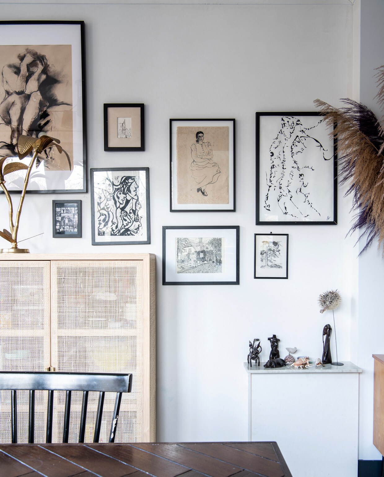 Kastje met webbing Ikea. Palmbomenlamp À La. Verzameling prints en tekeningen kringloop, familiestukken en zelfgemaakt. Eettafel Dutchbone. Beelden op lage kast souvenirs en cadeaus. Opgezette kogelvis Naturalis. Overig onbekend.