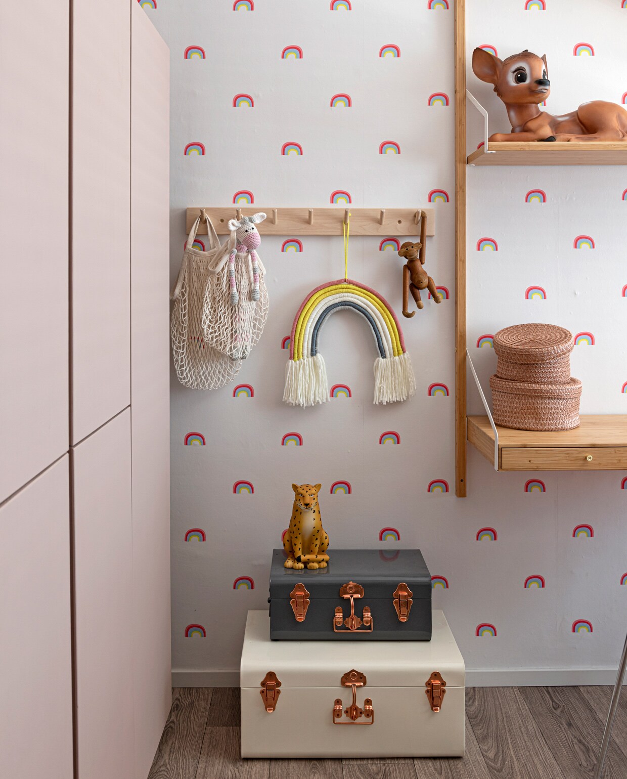Kisten House Doctor, spaarpot Leopard van The Zoo via Loods 5. Regenboogfiguur, behang en bakjes op plank Kwantum. Kapstok Mevrouw Aardbei. Wandmeubel Svalnäs Ikea, nachtlamp via Marktplaats. Items aan de kapstok Ikea, Kwantum, Marktplaats.