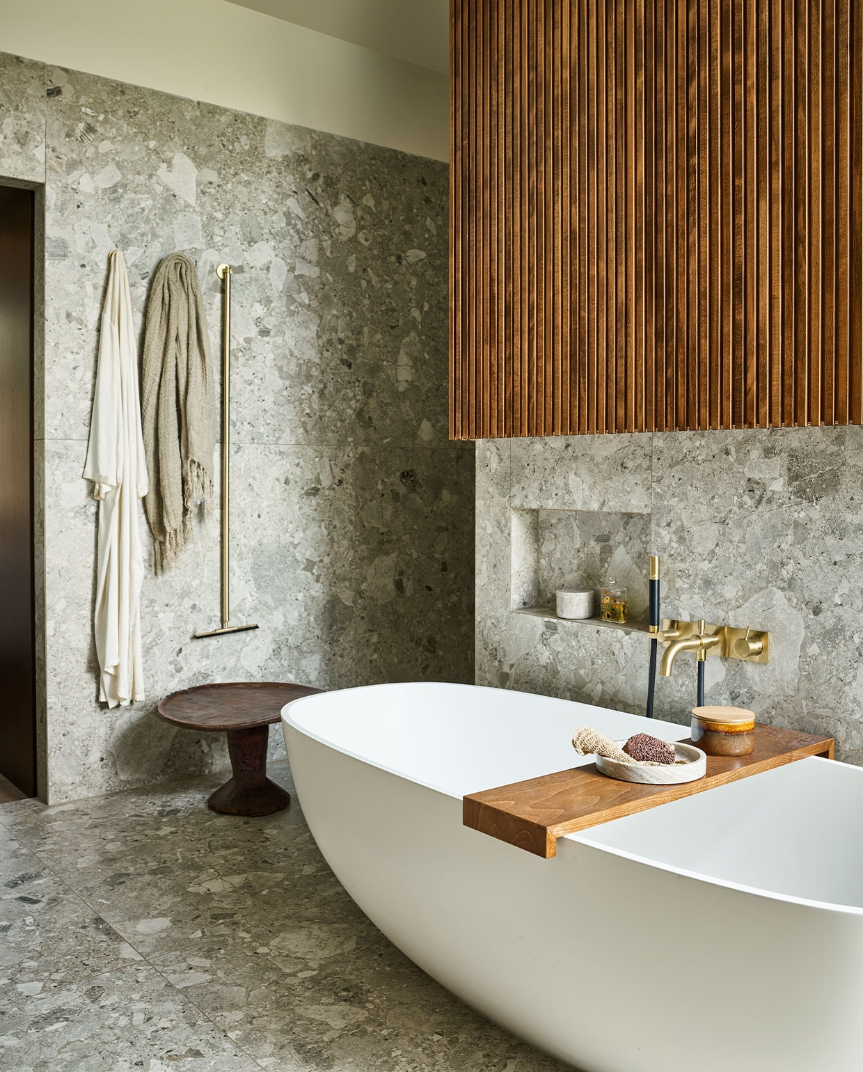 Vrijstaand bad Dado Quartz, prijs op aanvraag, grote tegels Light Grey Composiet uit de vtwonen-collectie, 120×120 cm, per m2 € 80,75, messing badmengkraan Hotbath Cobber CB026 met handdouche, vanaf € 798,60 (tonscholten.nl). Linnen badlaken € 80,50, marmeren schaal, € 69,95, marmeren potje, € 69,95 (nordal.eu). Houten bijzettafel Jimma, € 335,- (couleurlocale.eu).