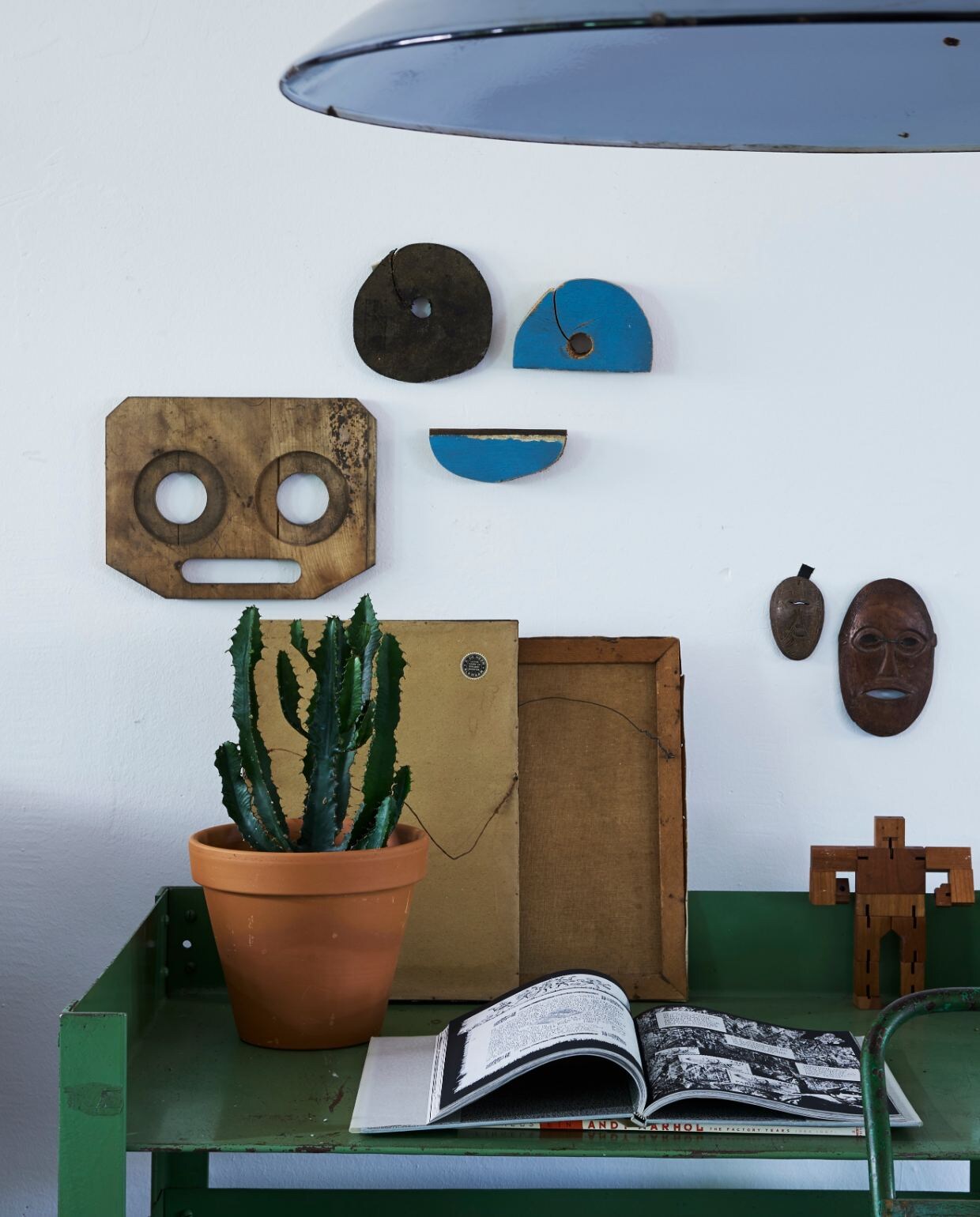 Oude poort meegenomen uit India. Pauwstoel, manden, plantentafels en zelf wit gespoten kruk Zenza. Overige in kast souvenirs, vintage vondsten en dierbare items, zoals een naaidoos die Karins opa heeft gemaakt. Tafel Raw Materials.