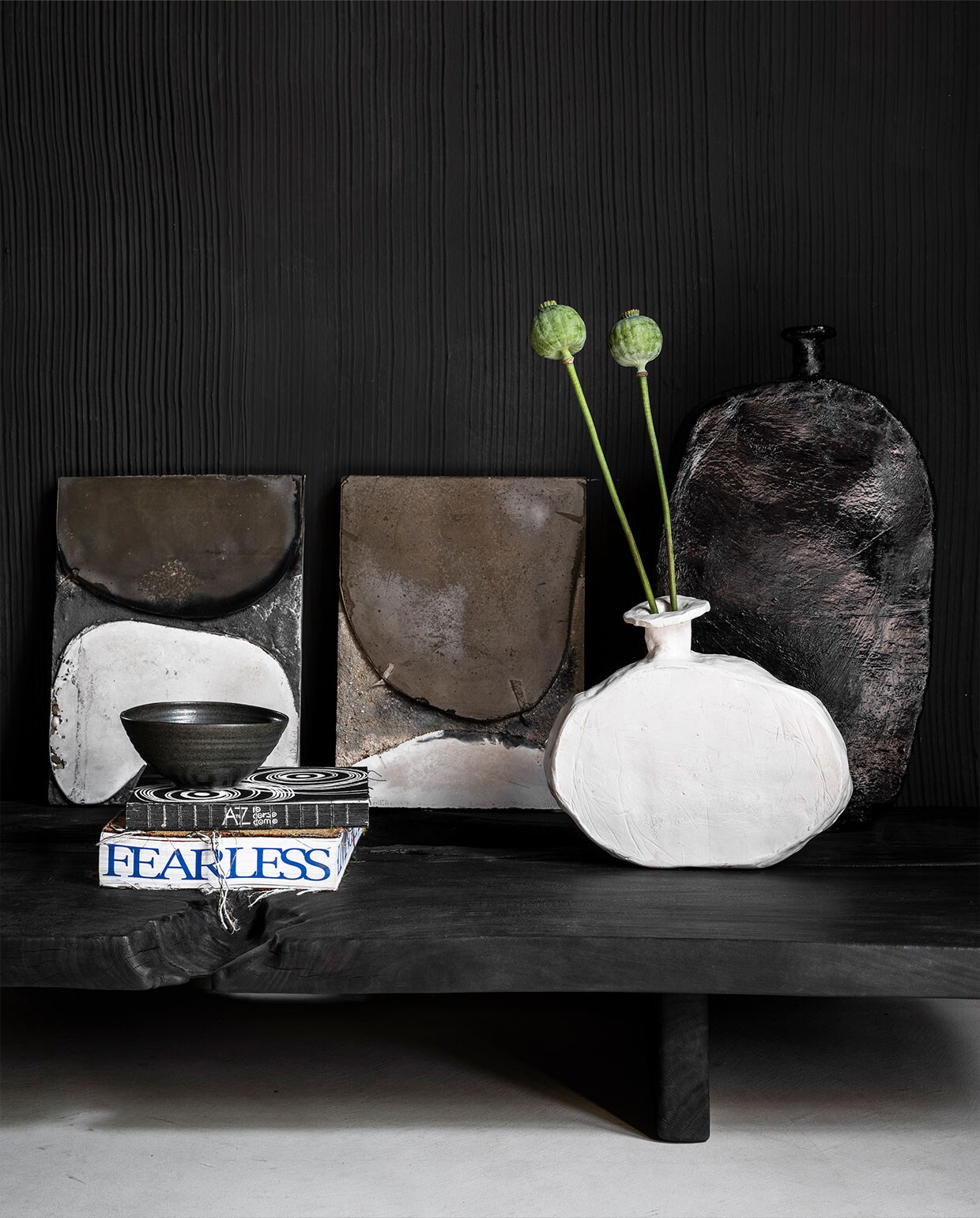 Handgemaakte lage tafel van gebrand hout, in diverse maten vanaf € 2500,- (wdstck.eu). Handgedraaide kom van Marjoke de Heer € 35,- (marjoke­deheer.com). Witte en zwarte vaas van Willem van Hooff, prijs op aanvraag (willemvhooff.com). Achtergrond: betonnen reliëfkunst van Marlies Hoevers, prijs op aanvraag (hoeversid.com). Overig privébezit.