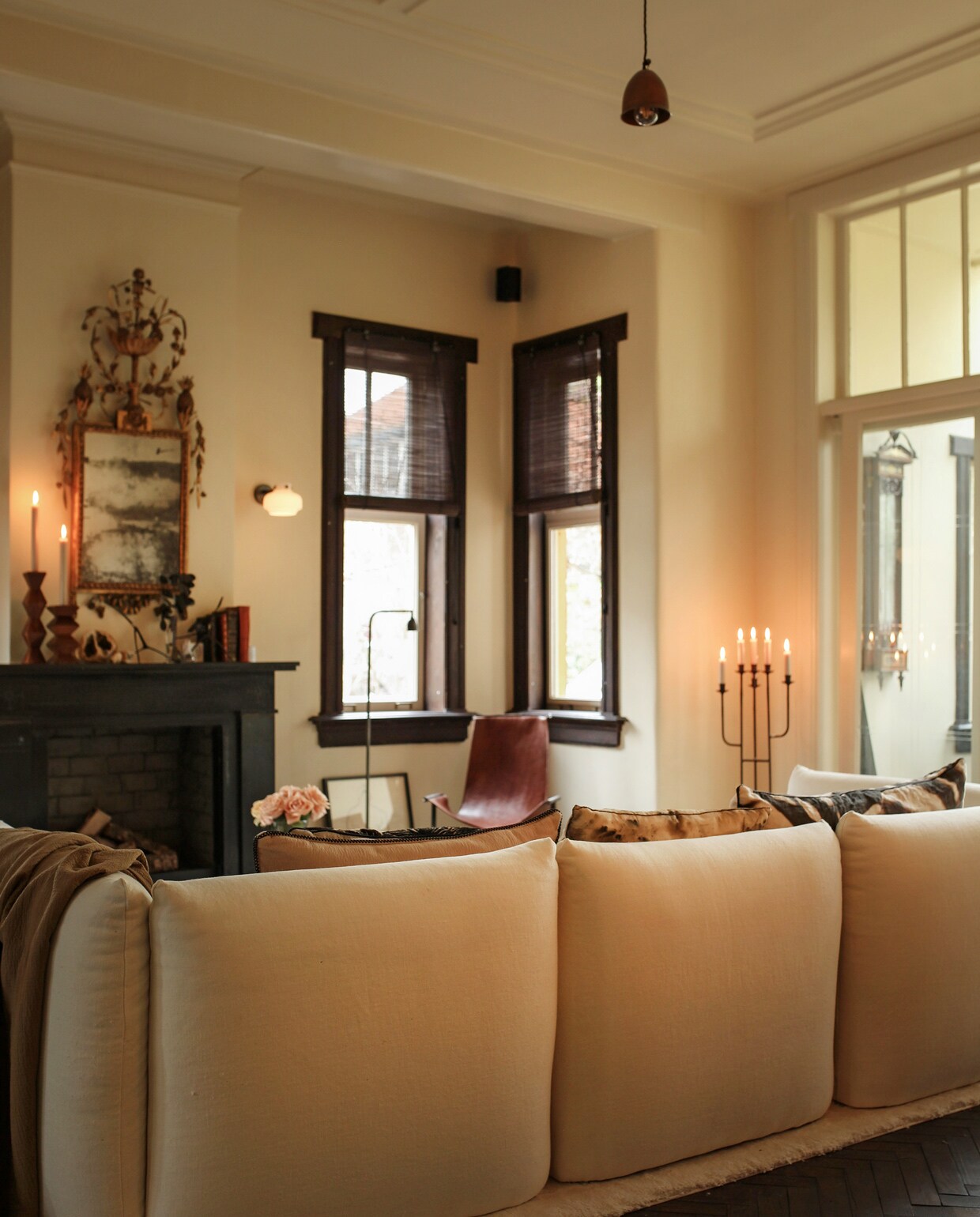 Bank l’Authentique, op maat gemaakt vloerkleed Cunera. Antieke spiegel van een veiling. Vloerlamp en leren fauteuil Brecht Murré Atelier, wandlamp &amp;tradition via Eijerkamp, kandelaar tweedehands.