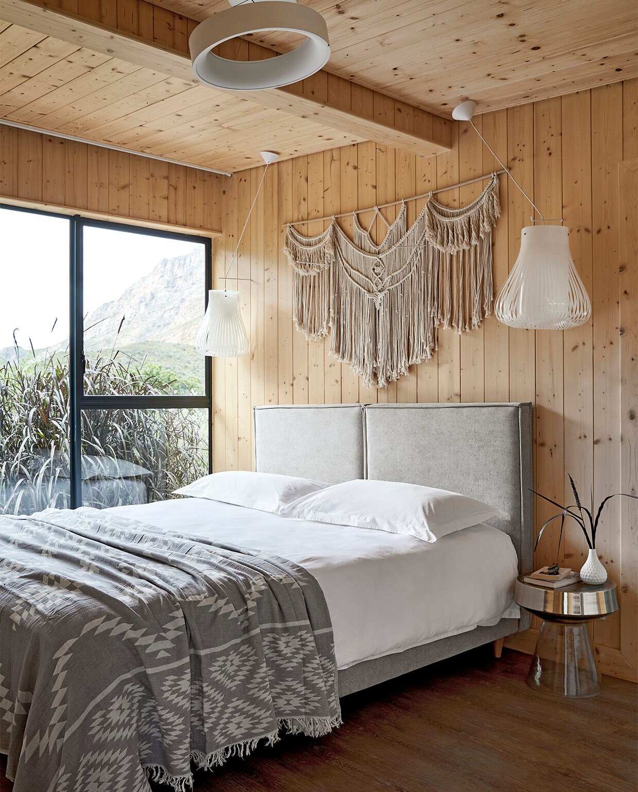 Op maat gemaakt bed en hoofdbord Giraffe Designs. Beddengoed Lifsons en White House. Plaid The Cotton Company. Bijzettafel Weylandts. Hanglampen Eurolux. Wandhanger No Negative.