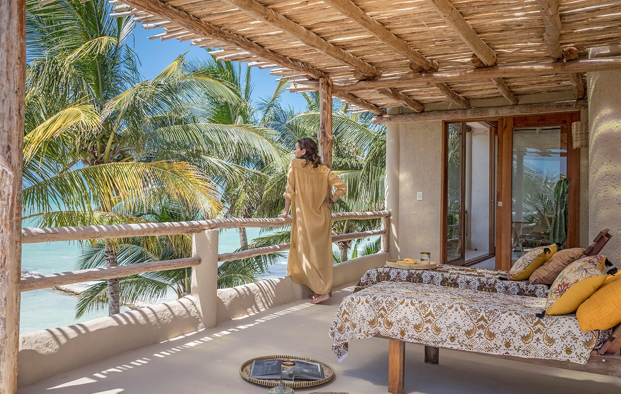 Het terras van de Palapa Suite op de derde verdieping, met buitendouche en uitzicht op zee. Beddengoed en kussens Harmony Textile.
