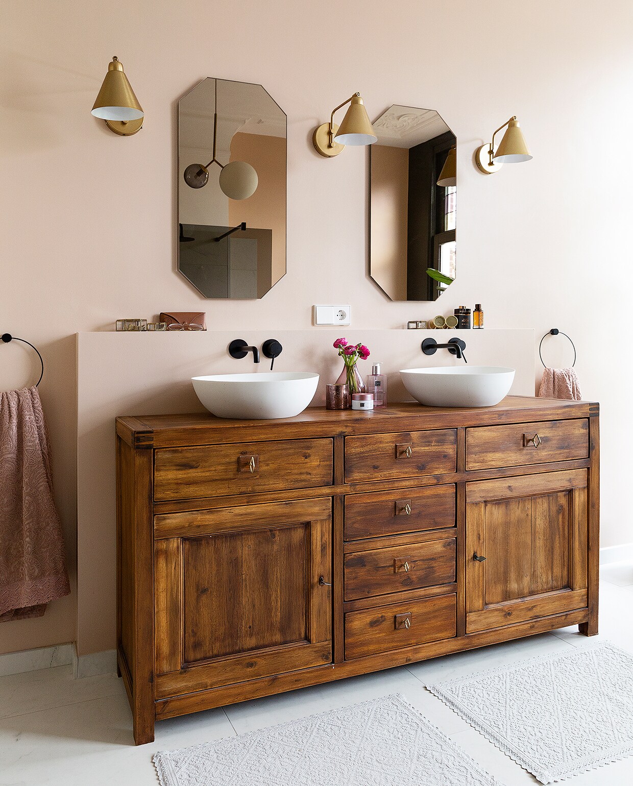 De kast is vintage. Wasbakken van Riho en kranen van Fima, alle via Stone Company. Badmatten Zara Home. Wandlampen House Doctor. Spiegels op maat gemaakt door een glashandel. Handdoekringen Ferm Living.