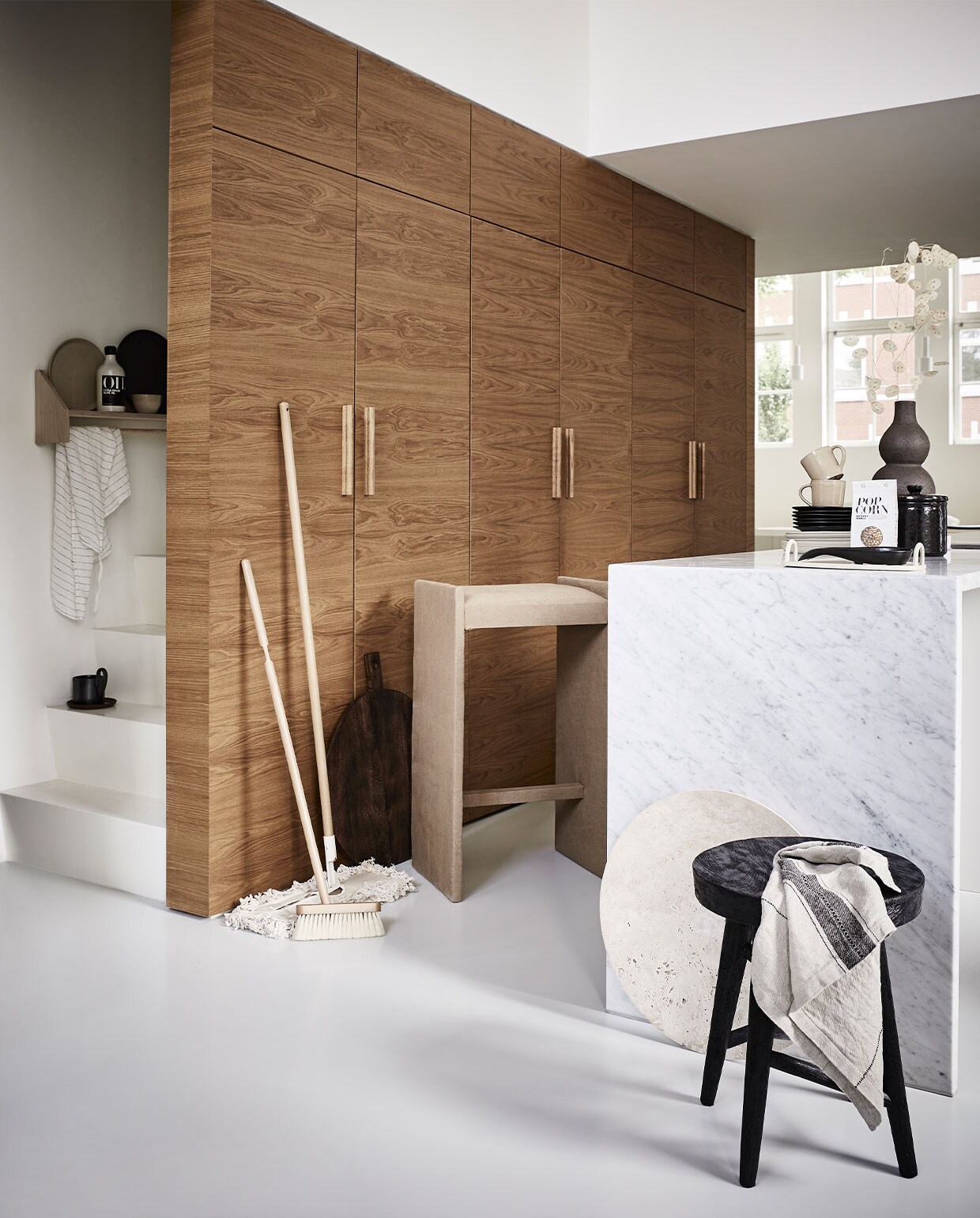 Kruk kringloop € 7,50 (kringloopwinkelleiderdorp.nl) bekleed met stof per meter € 39,95 (stof.nl). Dweil € 59,99, bezem € 22,99, zwarte pot € 17,99 en zwarte lepel € 12,99 (zarahome.com). Houten, ronde snijplank € 29,99, zak popcornmaïs € 5,99, bruine vaas € 39,99, zwarte kruk € 59,99 (hm.com). Droogbloemen (waterdrinker.nl). Stenen, ronde serveerschaal € 480,- (homestede.nl). Wandrek Reizo € 132,- (sukha.nl). Fles olijfolie € 17,95 (nicolasvahe.com). Beige bord € 22,90, donkerbruin bord € 22,90, mokje € 9,90, theedoek € 27,90, mokken met oor per stuk € 17,-, wit dienblad op aanrecht prijs op aanvraag, schoteltje op trap per stuk € 7,90 (letoile.store). Zwarte mok op trap € 19,- (fermliving.com). Borden Pure Serax per stuk € 17,99 (vtwonen.nl).