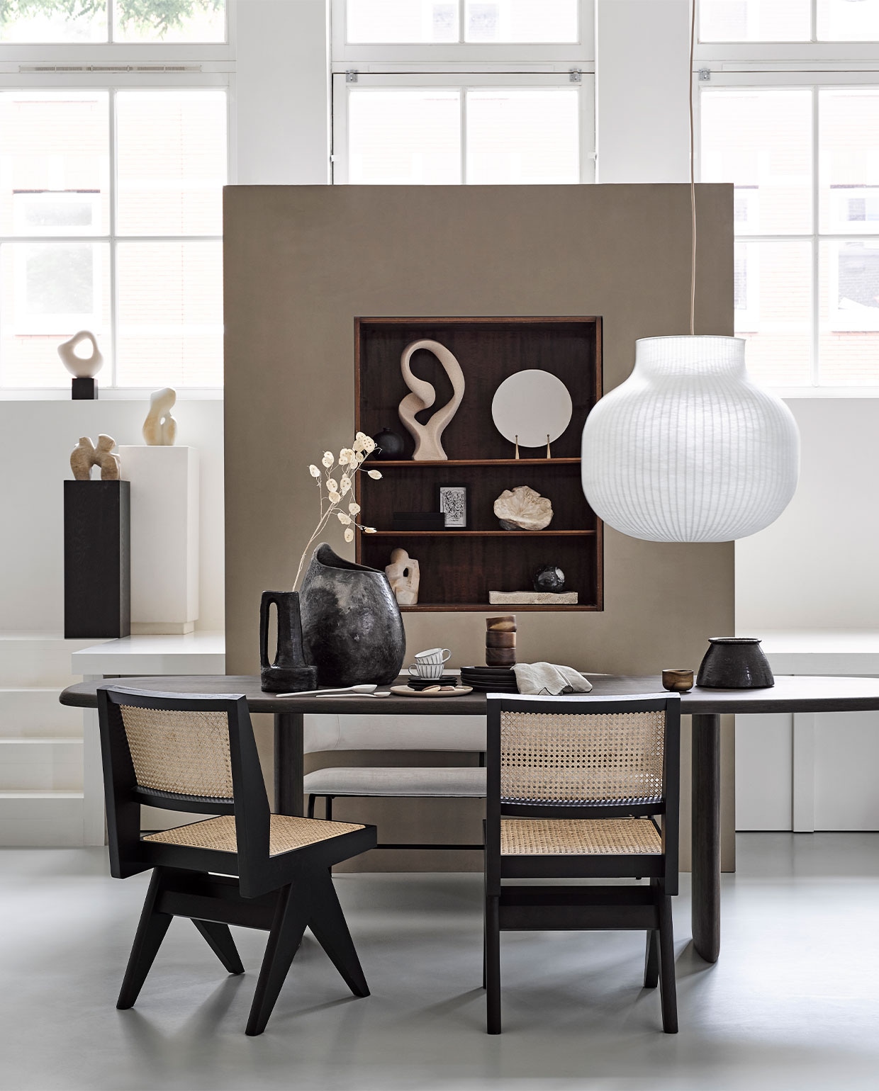 Lage kast € 60,- (com-anders.nl). Eettafel prijs op aanvraag (wdstck.eu). Stoelen € 1090,- van (edha-interieur.nl). Hanglamp Strand Closed van Muuto 80×54,8 cm (Øxh) € 795,- (loods5.nl). Bank Grazi van Mica Decorations € 310,-, beige ornament in kast € 86,-, servet Gracie in simply taupe van Broste Copenhagen, 45×45 cm € 11,95, houten mokjes Collage per stuk € 13,10, zwarte borden Inku per stuk € 14,30, groot bord Pure € 17,99,- en witte espressokoppen Inku van Serax per stuk € 2,30 (vtwonen.nl). Zwarte vaas met handvat € 89,- en grote vaas op tafel € 230,- (couleurlocale.eu). Droogbloemen (waterdrinker.nl). Witte pilaar € 85,- (covanderhorst.nl). Wit beeld in vensterbank € 24,99, bruine pilaar € 79,99, zwart bakje €19,99 en zwarte marmeren bol in kast € 24,99 (hm.com). Wit beeld op sokkel Aphrodite, 27 cm (h), bruin beeld op sokkel Soulmates, 22 cm (h) en wit beeldje in kast Stapeling 22 cm (h) prijzen op aanvraag (beeldenvansteen.nl). Ingelijste print gezicht in kast prijs op aanvraag (timothyvanoorschot.com). Klein papieren ornament in zwamvorm prijs op aanvraag (elsavisser.com). Marmeren schaal € 45,99, bord op standaard € 29,99 en zwart vaasje in kast € 39,99 (zarahome.com).