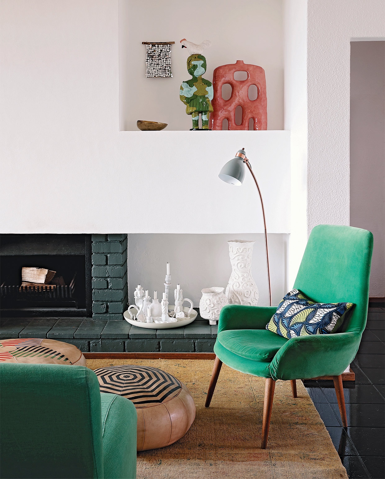 Vloerkleed Tirmah Interiors. Fauteuil erfstuk. Poefs Missibaba. Witte schaal met kandelaren her en der verzameld door Kerryn. Rood, keramieken kunstwerk Ben Orkin. Beeld meisje met haan Shirley Fintz. Schaaltje souvenir uit India. Overig onbekend.