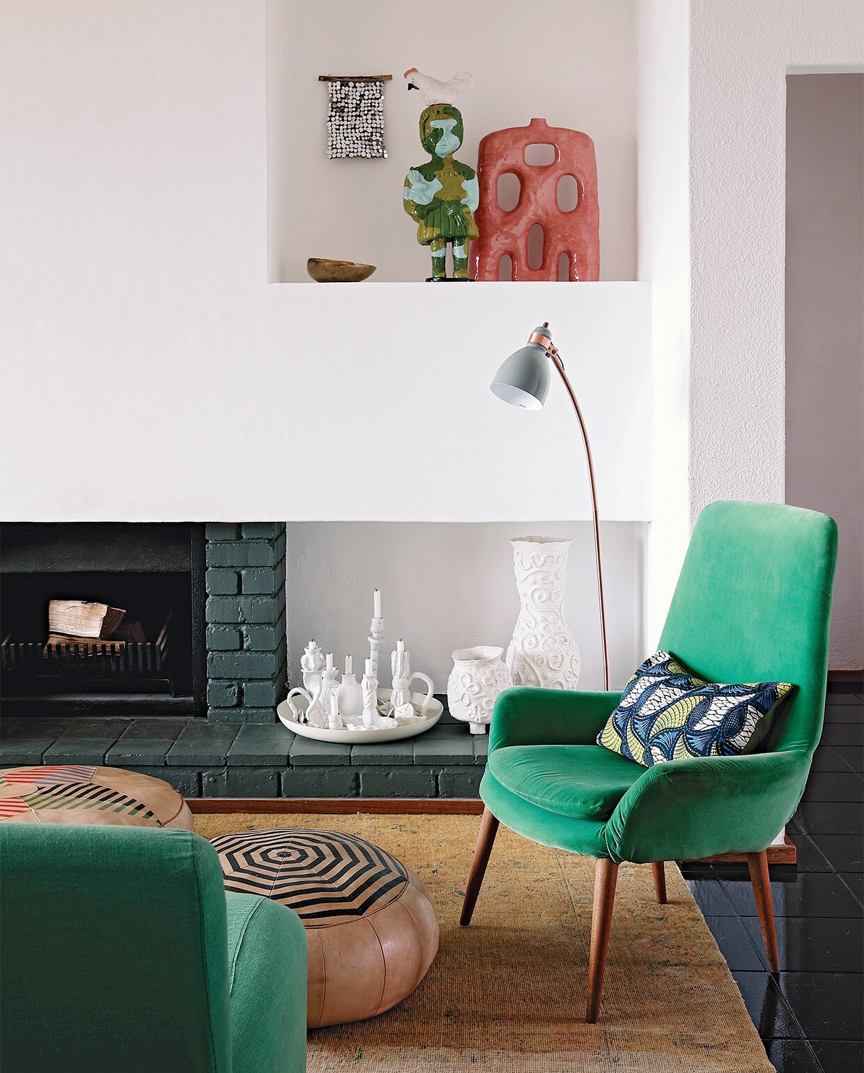 Vloerkleed Tirmah Interiors. Fauteuil erfstuk. Poefs Missibaba. Witte schaal met kandelaren her en der verzameld door Kerryn. Rood, keramieken kunstwerk Ben Orkin. Beeld meisje met haan Shirley Fintz. Schaaltje souvenir uit India. Overig onbekend.