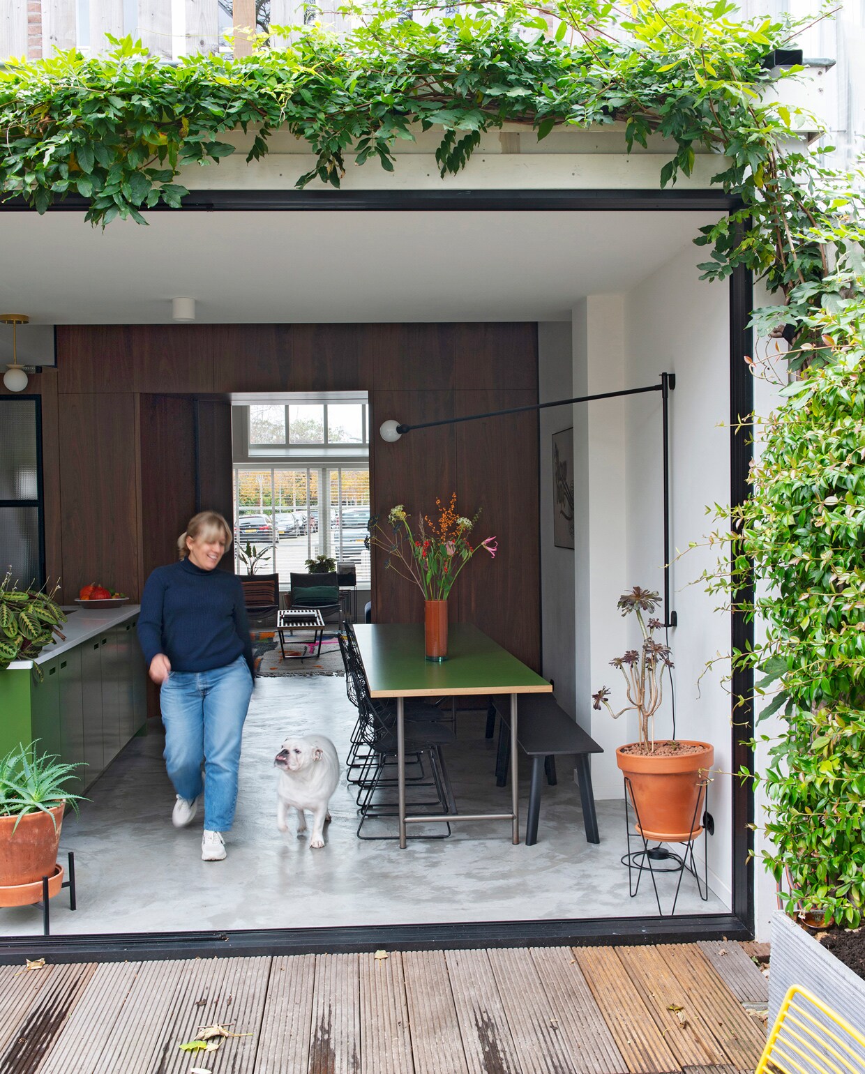 De schuifpui kan helemaal open. Dankzij de vlonders loopt het huis over de hele breedte over in de tuin.