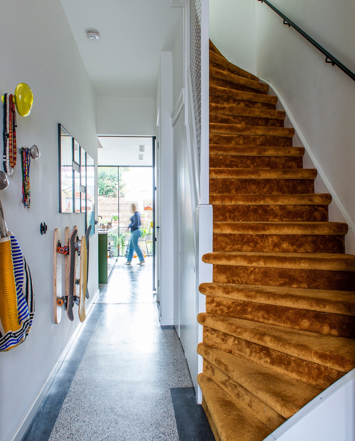 In de gang ligt de originele granitovloer uit de tijd dat het huis een drogisterij was. De trap is bekleed met velours voor een luxueuze uitstraling. Glazen hangers Petite Friture.