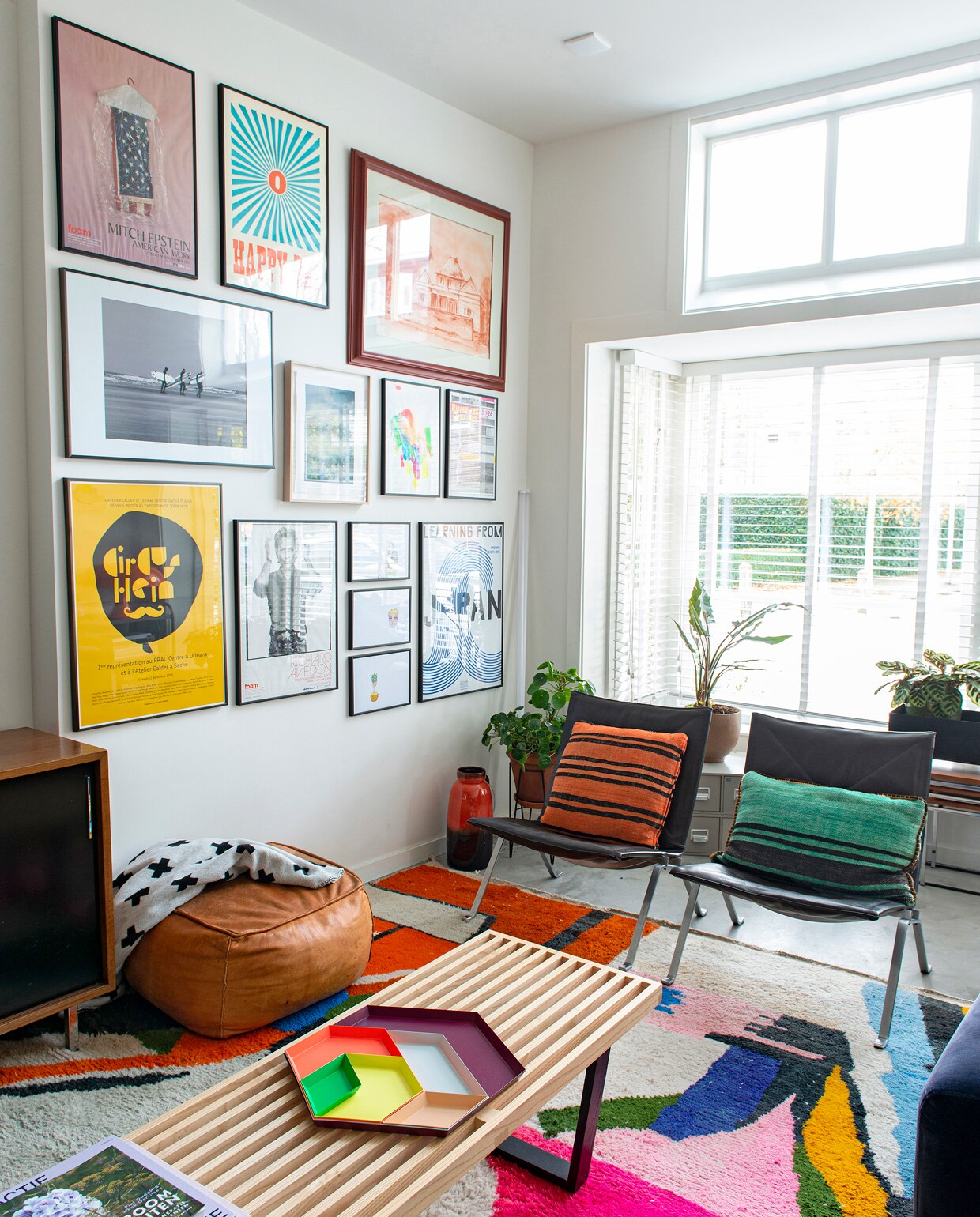 Karpet uit Marrakech, vintage Poul Kjaerholm fauteuils van schoonouders overgenomen, salontafel van George Nelson voor Vitra, kussens uit Barcelona, poef uit Marokko. Houten bank en dienblad Kaleido van Hay. Lavavaas vintage vondst. Kunstwerken, prints en foto’s deels zelfgemaakt, deels van de kinderen en van vrienden, deels gekocht.