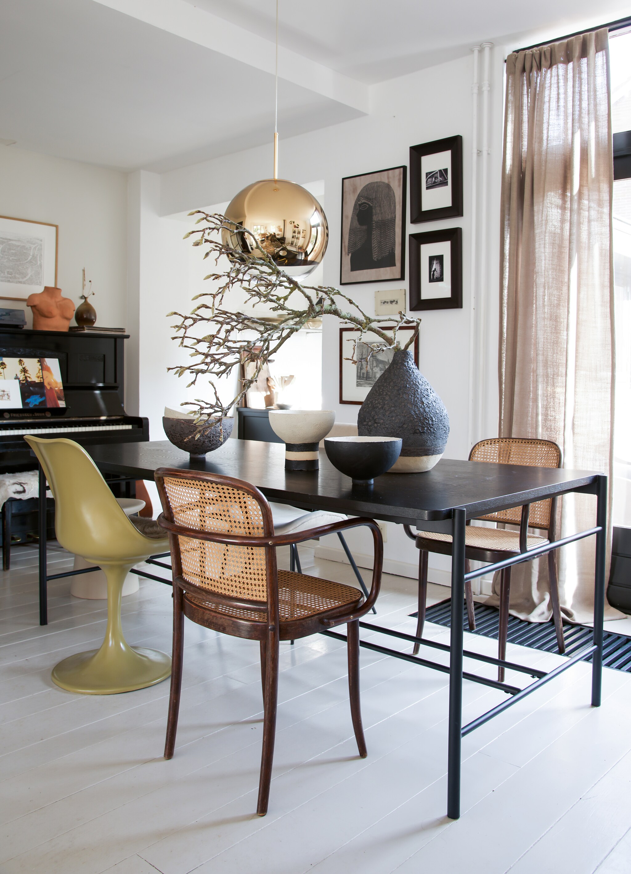 Oude Thonet-stoeltjes Marktplaats. Zwarte tafel Hübsch. Groene stoel met tulpvoet van Casa Gitane. Vazen en schalen handgemaakt door Liesbeth Spreeuwenberg. Designlamp Tom Dixon. Aan de wand een verzameling prints die Kris vond via Marktplaats en de kringloopwinkel. Foto’s via de kunstuitleen in Leiden.