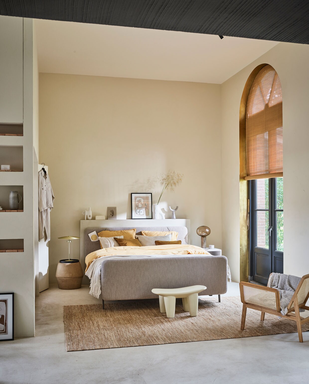 Boxspring Lifestyle by vtwonen Basil vanaf € 1650,- (140×200 cm), verkrijgbaar met verschillende stoffen en kleuren. Hier uitgevoerd met optioneel voetbord, stof Arcade Natural, metalen frame in kleur Champagne en poot Track.M.m.v. vtwonen.nl (goudkleurige lamp van Bolia, vaas van vtwonen, beddengoed Earth in kleur geel uit de vtwonen collectie), anoukb.com (fauteuil en witte kruk, schilderij, vloerkleed), nordal.eu (lamp met glazen bol, marmeren kandelaar, marmeren potje, ecrukleurige kussens), hm.com (linnen pyjama, linnen sprei). Overig privébezit.