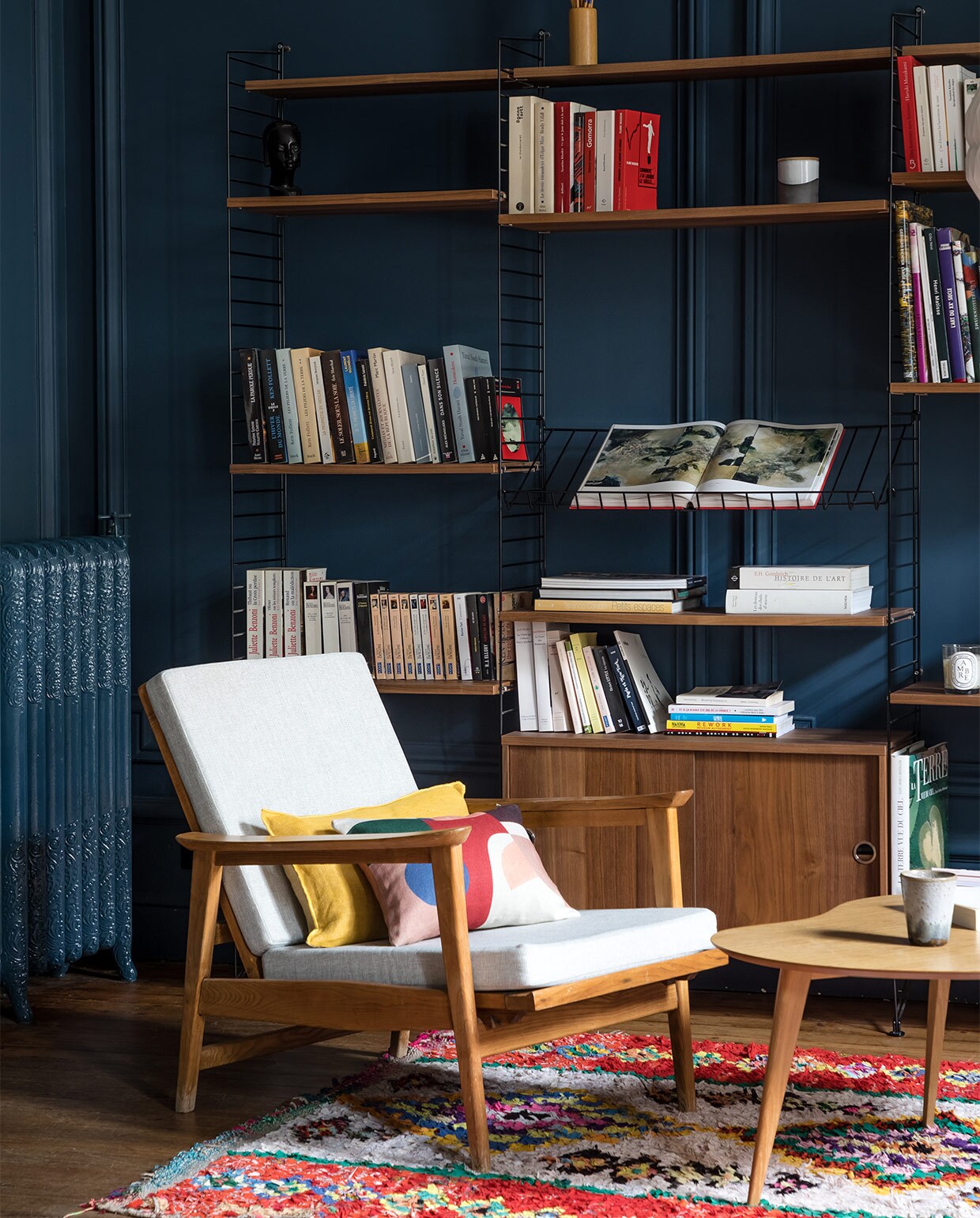 Boekenkast String Docks Design. Stoel tweedehands. Vloerkleed meegenomen uit Marokko. Koffietafel Sentou.