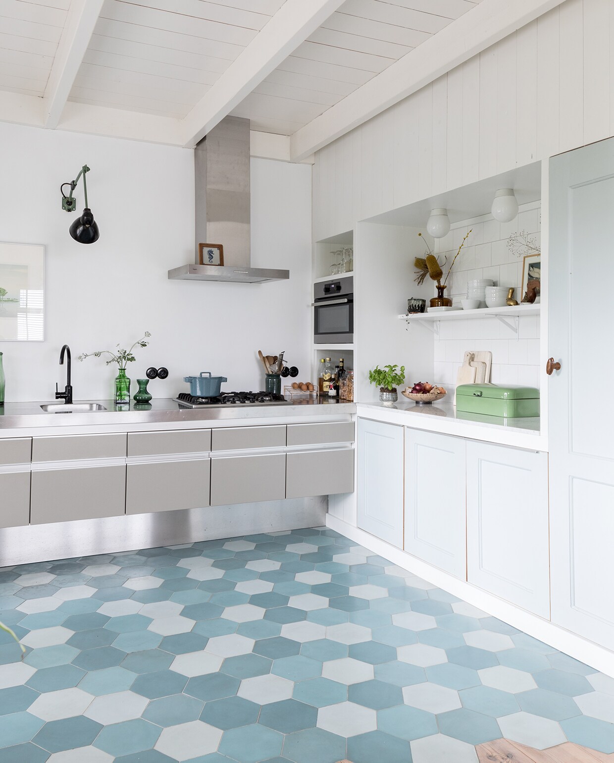 Glanzende wandtegels Praxis. Fruitschaal Marktplaats, emaillen broodtrommel rommelmarkt, roze waterkoker Stelton. Pot en fles op plank Sip &amp; Clara Pop-up Store, witte porseleinen bakjes Arzberg. Pelikanen-verzameling uit Belize, New York en Hemelum. Vintage porseleinen plafondlampen Wilhelm Wagenfeld.