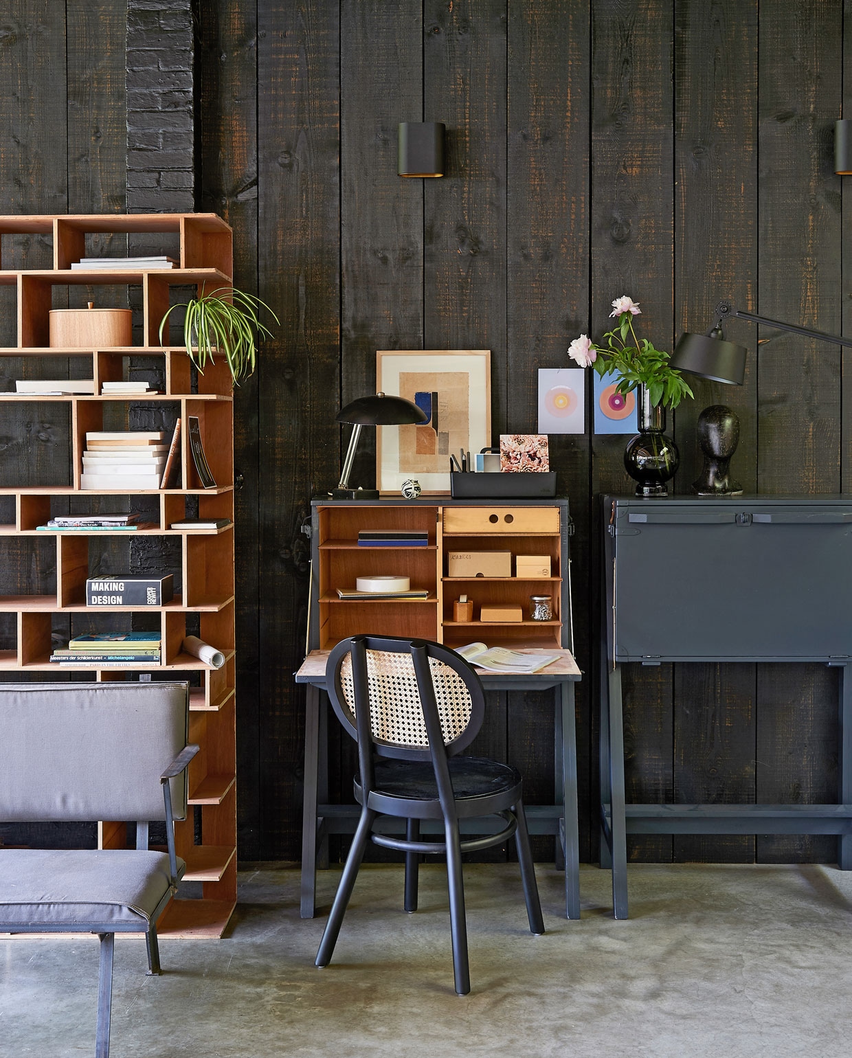 Bureau gemaakt van kisten, fauteuil met stalen frame, vakkenkast (com-anders.nl). Retro stoel, houten opbergbox, wanddecoratie in houten lijst sculptuur No Face (hkliving.nl). Taupe glazen vaas (loods5.nl). Staande lamp (design5.nl). Vintage lampje (demachinekamer.nl). Toolbox van Vitra (vtwonen.nl). Overig privébezit.