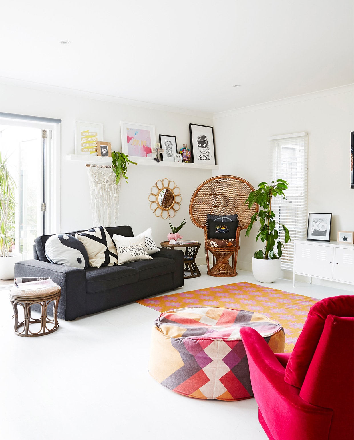 Yin-en-yangkussen, kussen Locals Only en regenboogkussen Kawaiian Lion. Grafisch zwart-witkussen Target. Macramé wandhanger Family Threds. Rotan bijzettafels en stoel gevonden op straat. Roze neushoornplantenpot Rice dk. Witte locker PS Ikea. Print XO Loneley Sea. Poef Pony Rider. Overig onbekend.