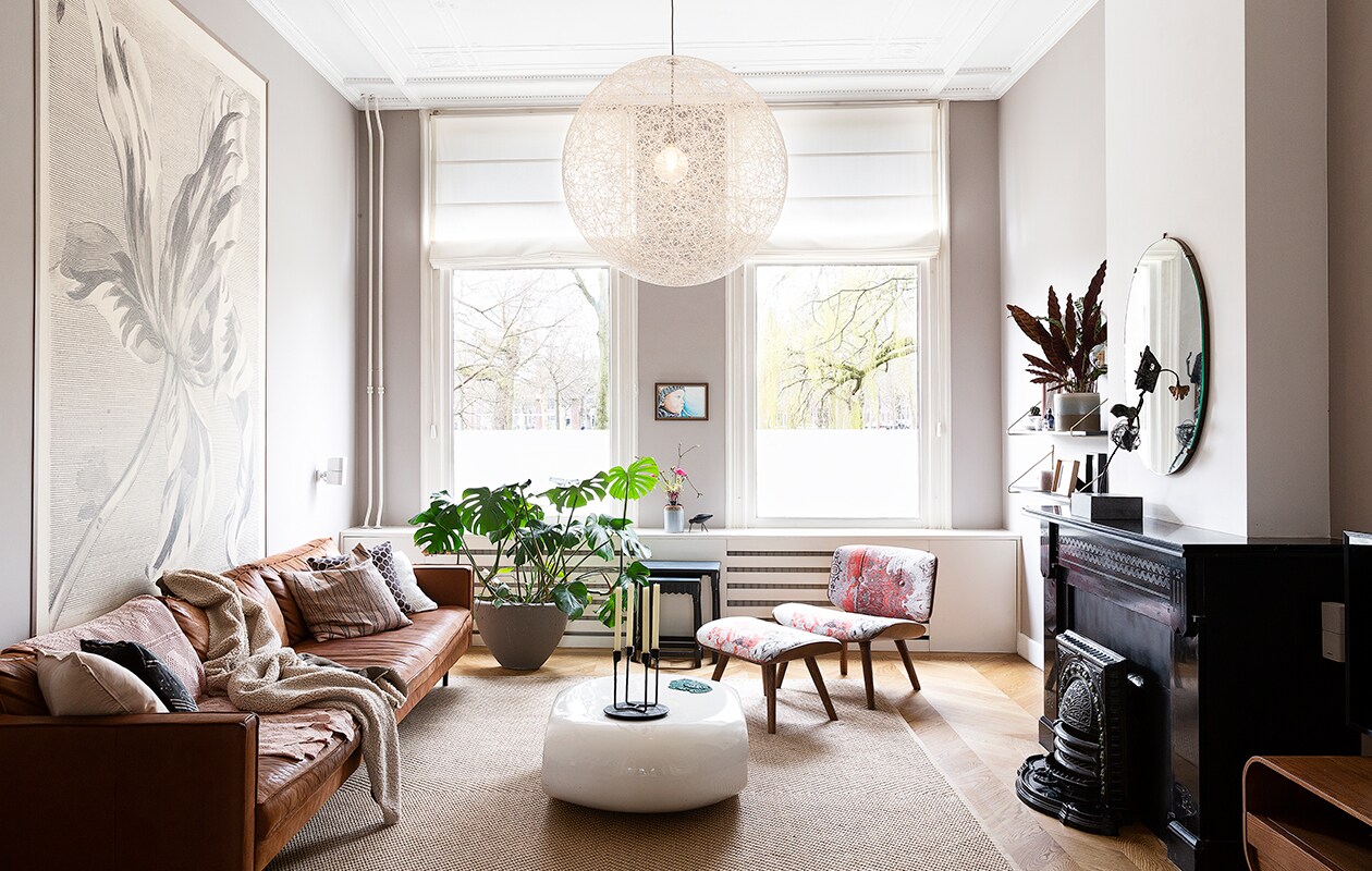 Behang Eijffinger. Bank Loods 5. Kussens Loods 5, Zuiver en Ikea. Plaid gemaakt door Merijns oma. Salontafel in België gekocht. Vaas Bloomingville. Kandelaar Normann Copenhagen. Voetenbank en lamp Moooi. Bloempot Flow Rotterdam. Vloerkleed Ikea. De tafeltjes waren van Stans oma. Portret gemaakt door Merijns oom.