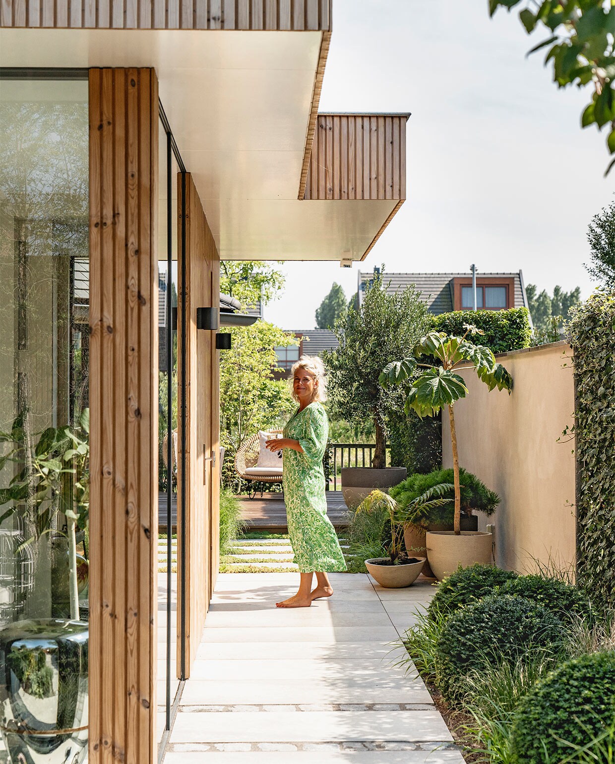 Latten rondom het huis thermopine design rabat. Keramieken buitentegels MBI. Ramen via aannemer. Buitenverlichting In-lite. Bloempotten van Atelier Vierkant via The Garden Store.
