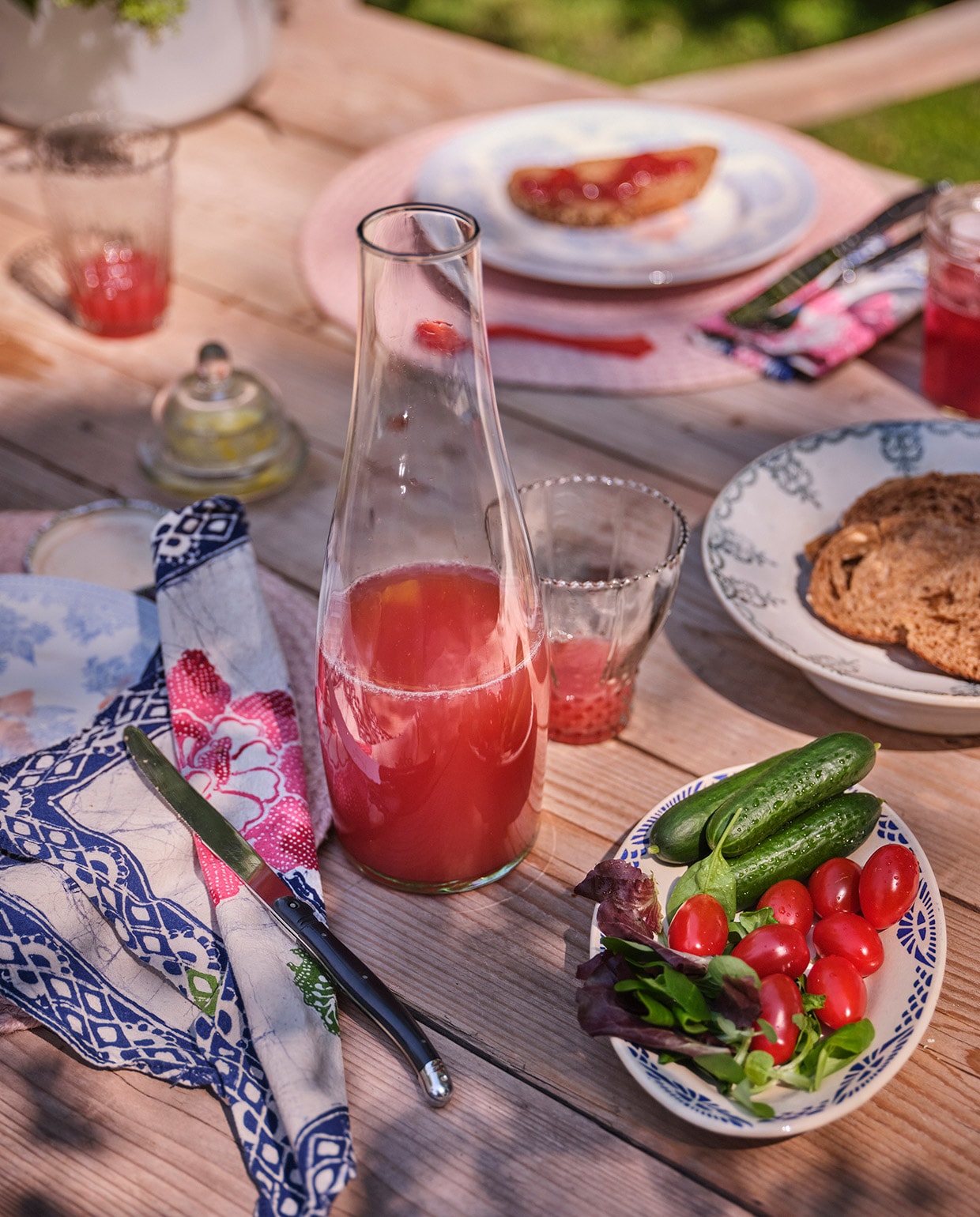 Het gebloemde servies, waar het Laguiole mes op ligt, is van Burleigh. De jam is gemaakt van vruchten uit eigen tuin. Karaf Sissy-Boy Homeland. Oranje lepeltje Sabre. Batik servet uit Indonesië. Placemats Bloomingville. Overige items brocantemarkten.