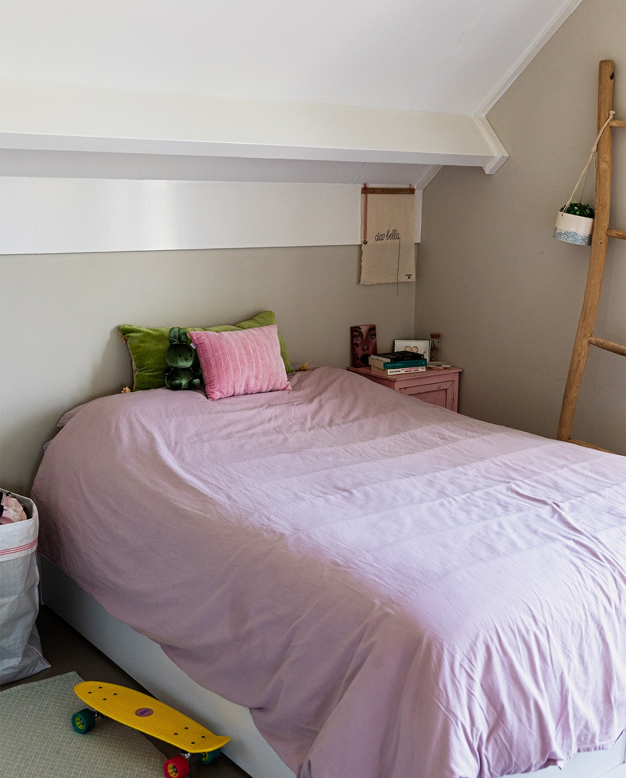 In deze kamer slaapt dochter Lotte als ze komt logeren. Dekbed Hema. Kussens Goround Interior. Pennyboard van Toychamp. Wanddoekje Lemonwise. Kunstwerk op nachtkastje van Iraanse kunstenares Ghazaleh Afrand. Overig herkomst onbekend.