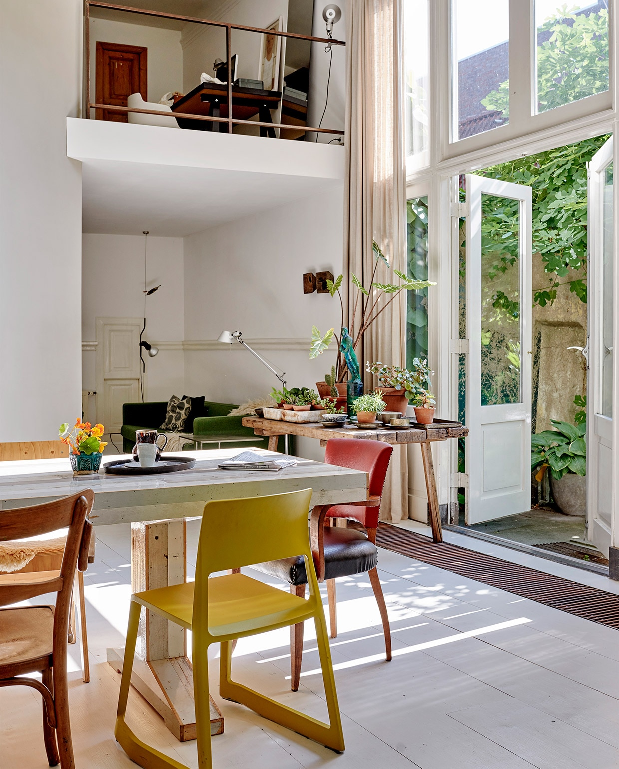 Oude grenenhouten vloer, wit geschilderd. Gele stoel Tip Ton van Vitra via Van Duivenboden. Eettafel Kantinetafel en stoel rechts voor Piet Hein Eek. Kandelaar Twiggy Large Sjakie’s. Kast Chiffonnière. Vogel raaf en dienblad Pols Potten. Kunst transfer op rijstpapier in houten lijst van Laurien Mulder. Papiermaché rat van Caroline de Bruijn. Vaas op tafel MrsBloom. Overig herkomst onbekend.