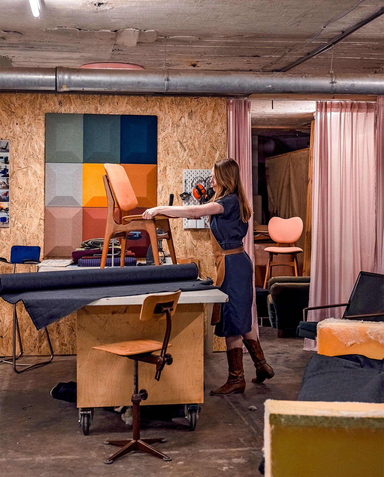 De studio is verdeeld in een stoffeerderij en een opslag voor materialen en meubels die net zijn binnengekomen of al klaar zijn. ‘Ik heb ook een vieze tafel en een schone tafel.’ Noor deelt de kelderruimte met Marisha van Zo Retro die fifties-meubels via internet verkoopt. Achter een roze gordijn is haar gedeelte, ramvol fraaie meubels.