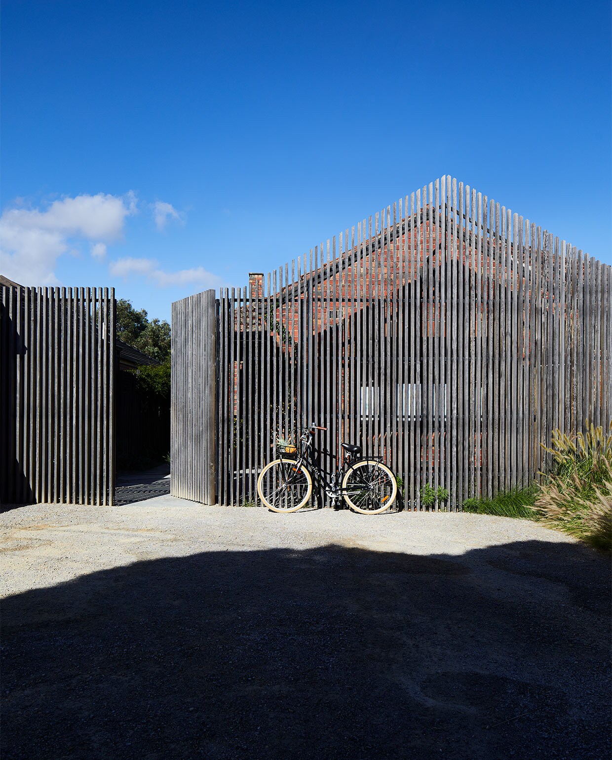 Het buitenhek, een ontwerp van Field Design Studio, volgt de contouren van het huis. Het is gemaakt van in de oven gedroogd hardhout, dat met de tijd mooier wordt.