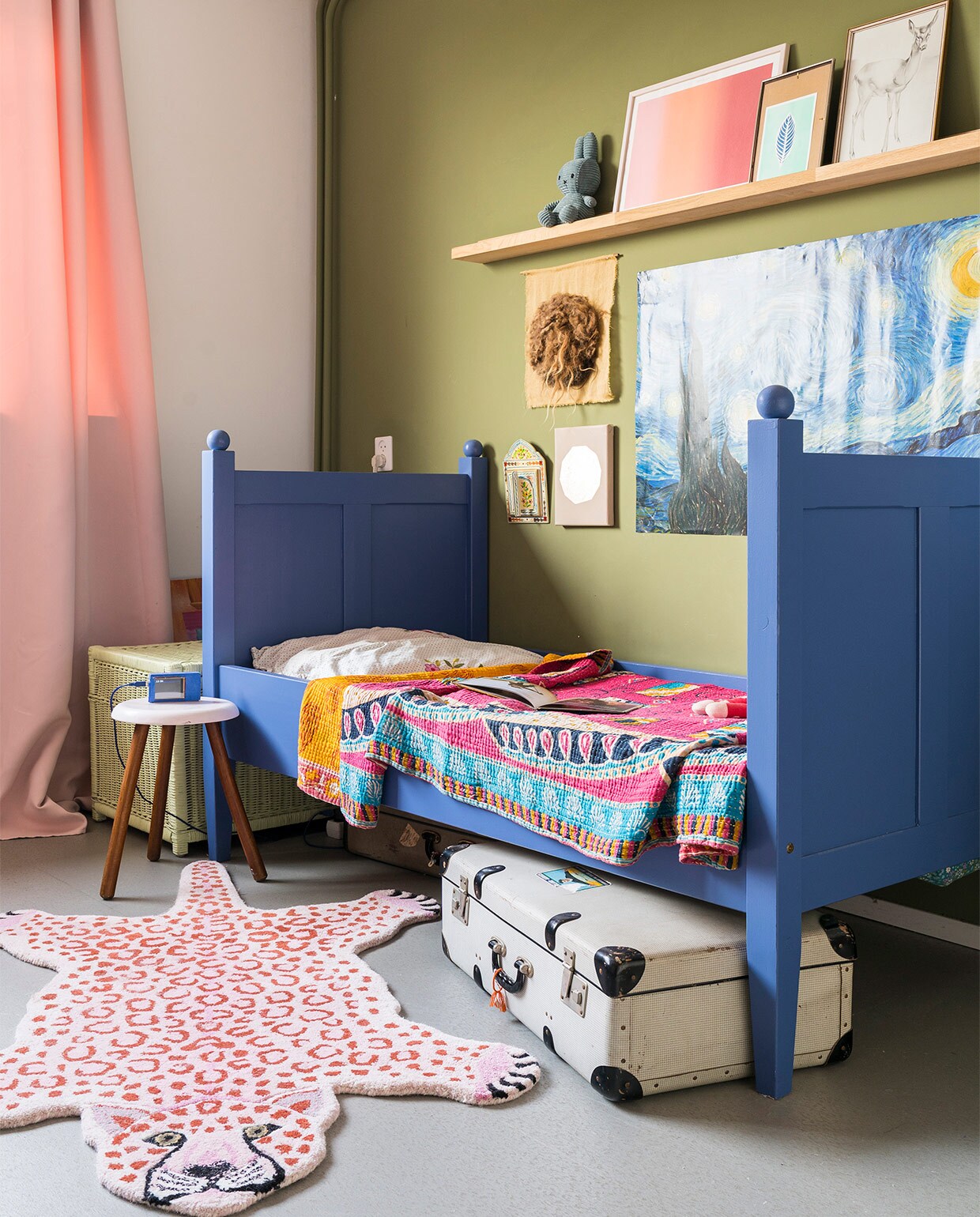 Verfkleur wand Olive van Farrow &amp; Ball. Verfkleur bed Ultra Marine Blue van Farrow &amp; Ball. Gordijn van La Redoute. Bed Marktplaats. Kantha-kleed uit India. Panter Doing Goods. Spiegeltje met deurtjes uit Marokko. Goudkleurige maan IrisDorine. Vilten Maan Halona. Van Gogh-poster Desenio. Op de plank Nijntje, soortgelijk bij De Winkel van Nijntje. Roze print Eveline Renzenbrink. Prent met veer We are out of office. Hert kringloopwinkel. Wekkertje geprogrammeerd door Timo. Beddengoed Hema. Plank herkomst onbekend. Overige kringloopwinkel.