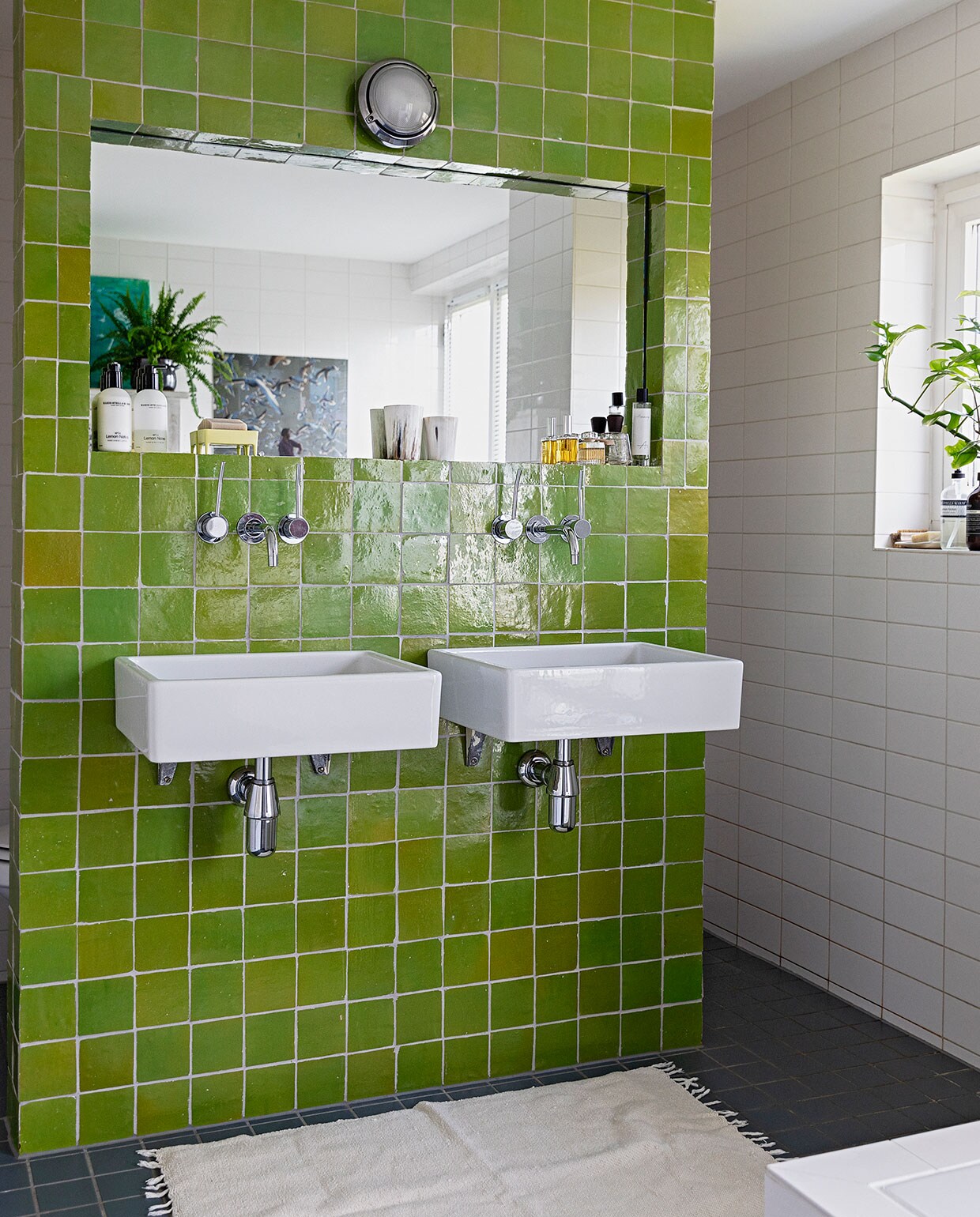 De bestaande witte badkamer werd opgefleurd met zelliges, Marokkaanse tegels. Sanitair Villeroy &amp; Boch. Lamp Luceplan. Kleed meegenomen uit Uganda.