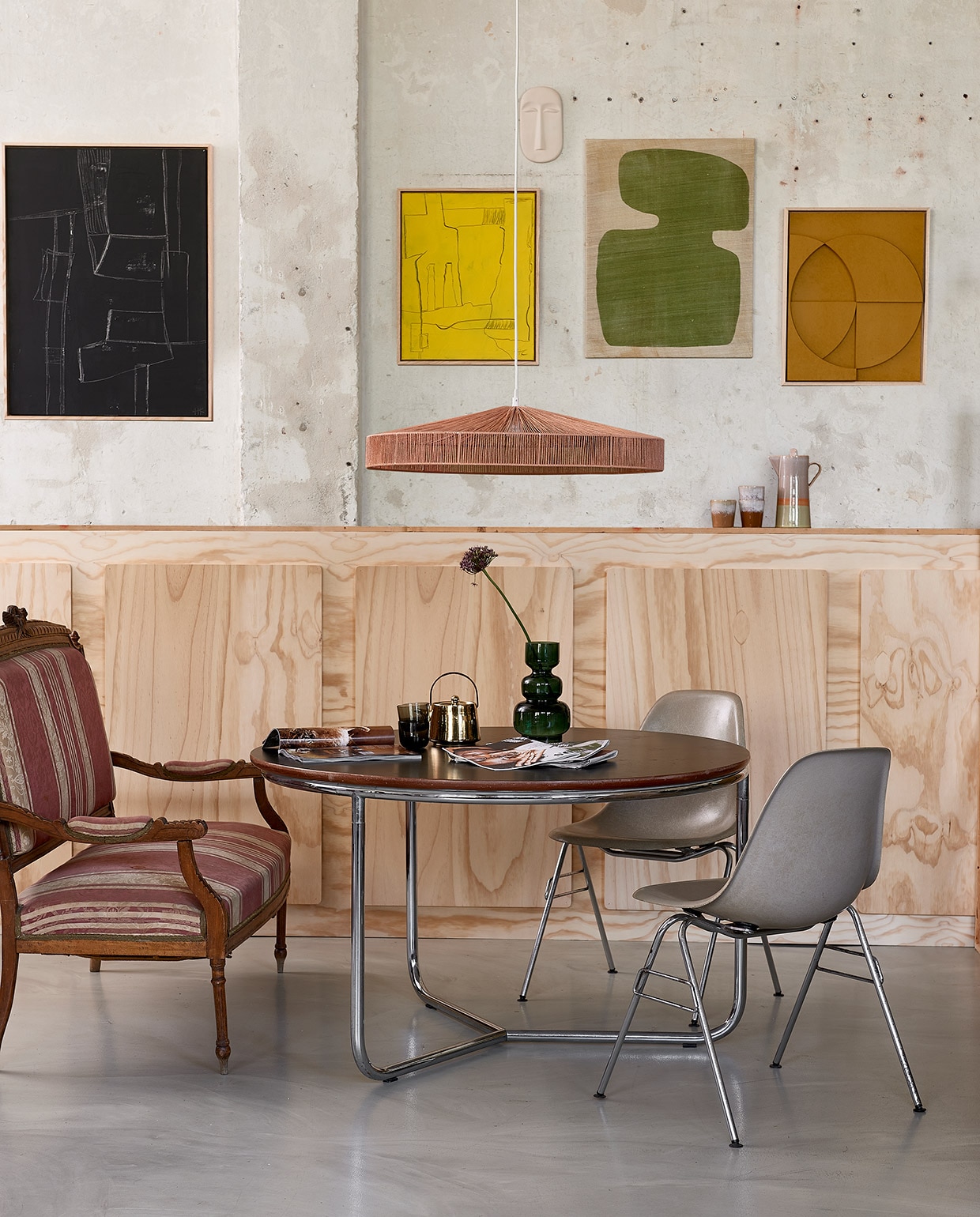 Vintage tafel, 100×76 cm (Øxh), vintage Eames kuipstoel (neeflouis.nl). Antiek bankje (vandijkenko.nl). Kunst aan wand: zwart, 60×80 cm, geel, 40×50 cm en oker, keramieken masker Chulucanas, hanglamp Terra Shades van touw, goudkleurige theepot, koffiekan Saturnus, mokken (hkliving.nl). Wandkleedvan Urban Nature Culture, 65×50 cm, diepgroene glazen vaas, 25 cm (h) (vtwonen.nl). Glaasjes (hm.com).