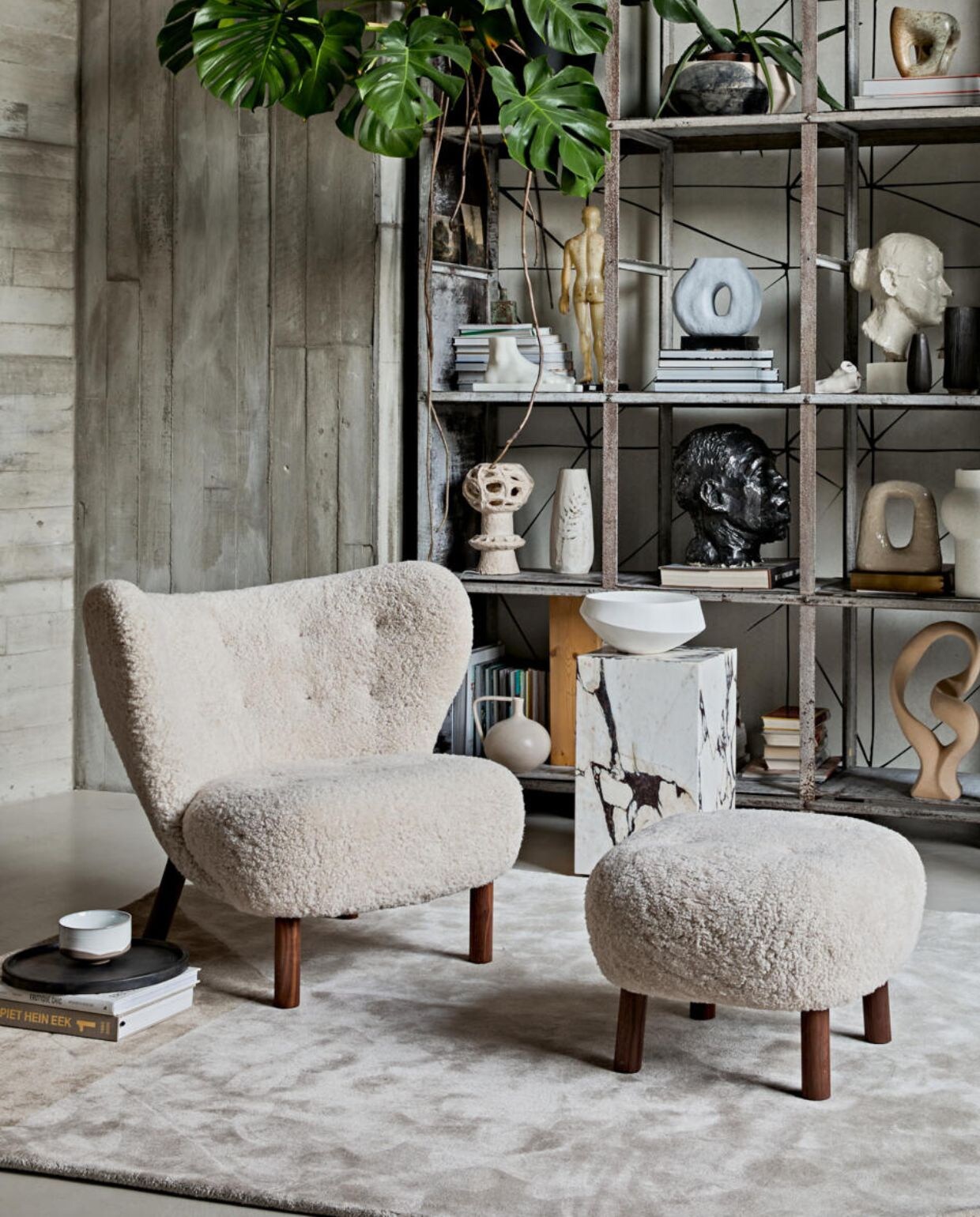 Keramieken vloerlamp retro cone xl, 40×140 cm (Øxh) € 449,- (hkliving.nl). Fauteuil en voetenbank met schapenvacht Little Petra van &amp;Tradition € 6113,-(kasstoor.nl). Vloerkleed Volume van Fest Amsterdam € 699,-, dienblad van Zone Denmark. 35 cm (Ø) € 50,-, kom van Merci n°1 van Serax, 12,5 cm (Ø) € 16,65 (vtwonen.nl). Marmeren bijzettafel Plinth Tall van Menu, 30x30x51 cm (lxbxh) € 999,95 (designtales.nl). Erop: schaal € 59,95 (urbannatureculture.nl). Behang achter kast JO2703-2 Tres Tintas, Cuzco per m² € 45,- (rebelwalls.com). In de kast, van onder naar boven: crème vaas met oor € 34,95 (hkliving.nl). Ecru sculptuur Stoneware van Bloomingville € 85,- (vtwonen.nl). Zandkleurige keramieken kaarsenstandaard Arch van Malwina Kleparska € 275,- (studio-yen.com). Vaas speckled round, 30 cm (h) € 39,95, polystone voet € 59,95 (hkliving.nl). Blauwe vaas met gat € 37,95 (vtwonen.nl). Stenen sculptuur € 900,- (lisette­leegwater.nl). Vintage hoofden en overige objecten (vintagehoarder.com). Wandbekleding en kast van locatie. 2021-02 | Fotografie Jeroen van der Spek | Styling Cleo Scheulderman