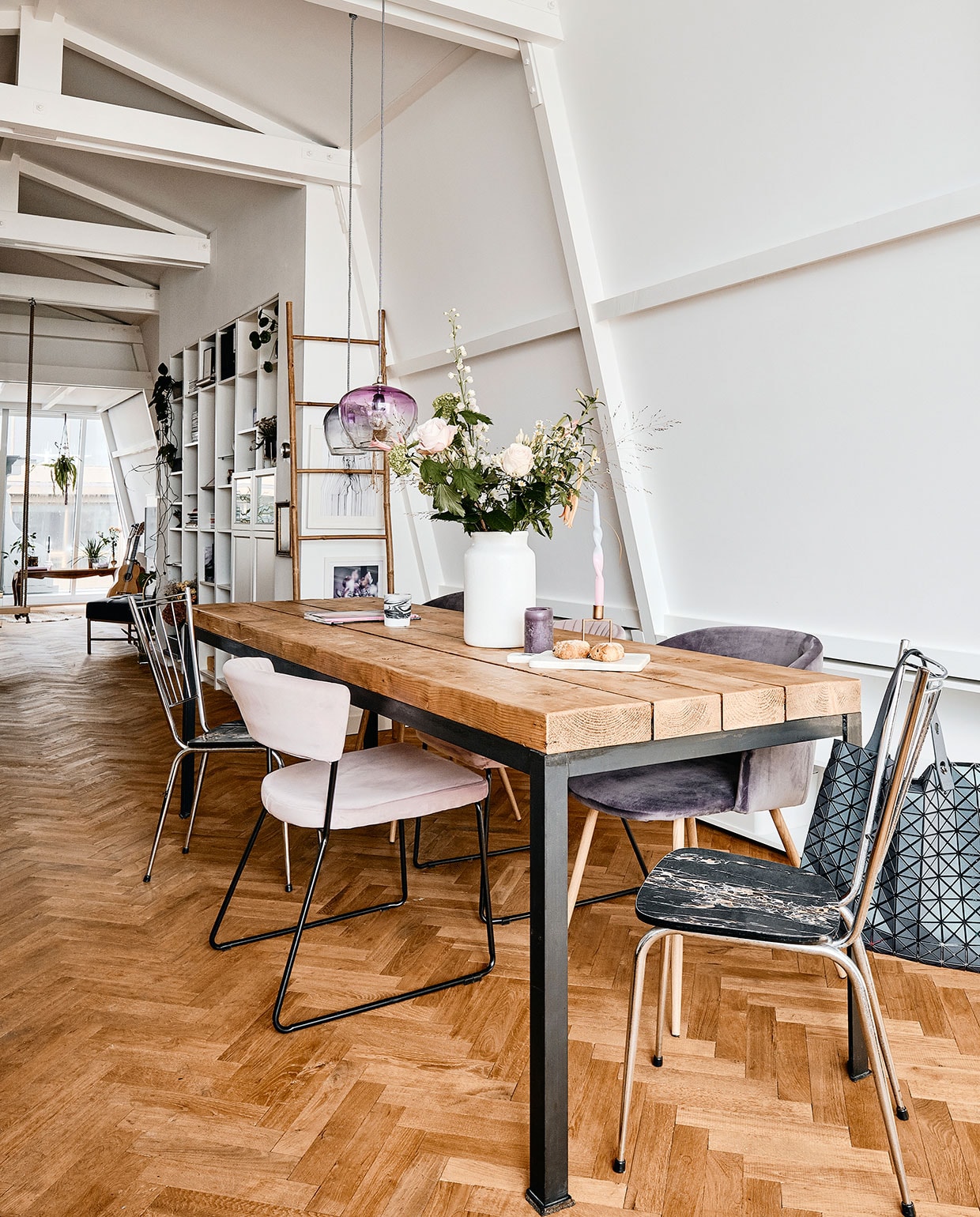 Eettafel en metalen stoelen Van Dijk &amp; Ko. Lichtroze stoel Giga Meubel. Paarse stoelen en paarse kaars onbekend. Witte vaas Bloomon. Kaars Diptique. Marmeren plank House Doctor. Kandelaar Sissy-Boy. Draaikaars Decor. Ladder en donkerblauwe en paarse hanglampen Loods 5. Posters Desino. Inbouwkasten Ikea. Tas Issey Miyake.