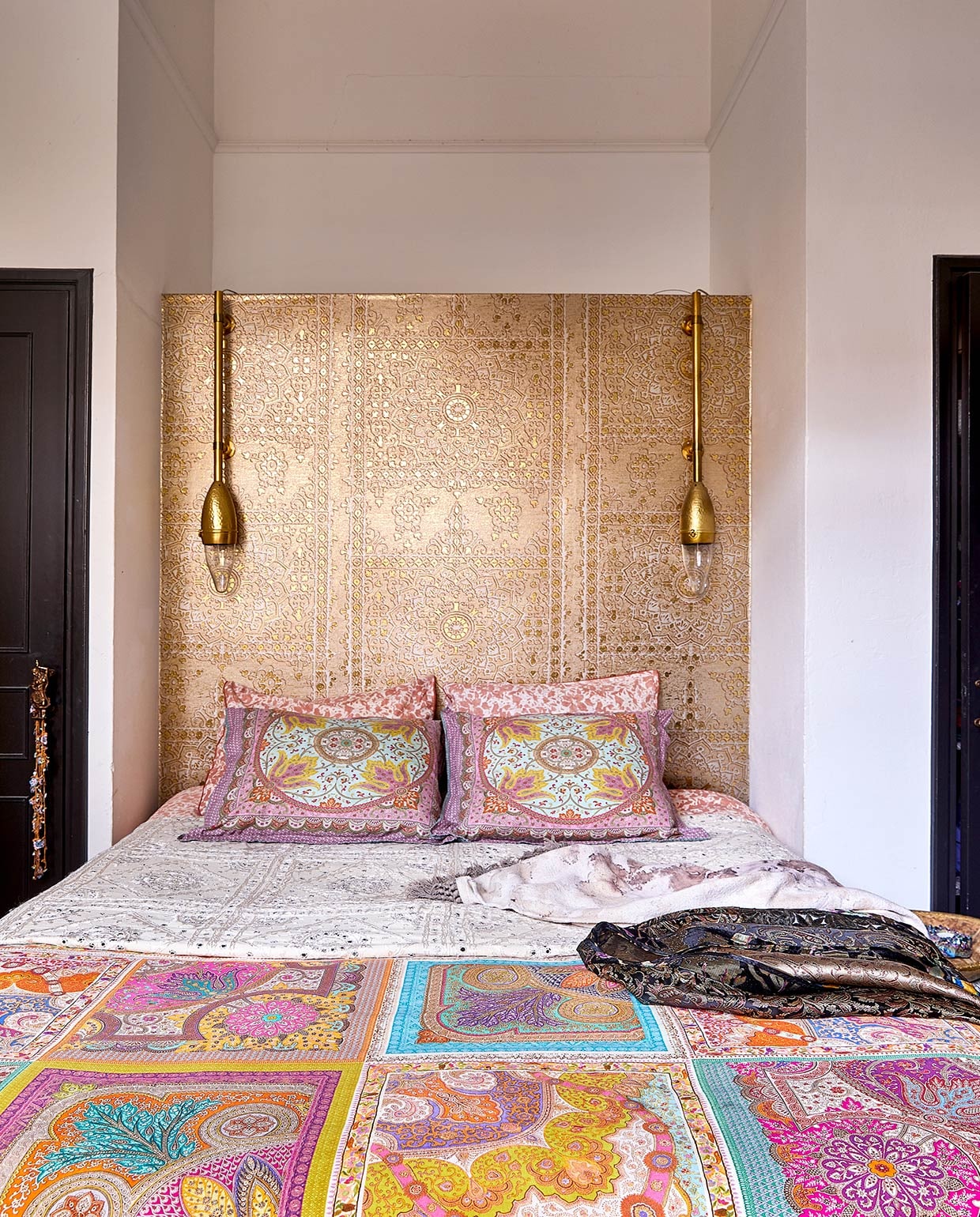 Zelfgemaakt hoofdbord met behang van Luxury By Nature. Lampen Zenza, Karin heeft er buizen aan bevestigd. Kussenhoezen Zara Home. Traditionele witte sprei met spiegeltjes uit India. Kimono zelfgemaakt.