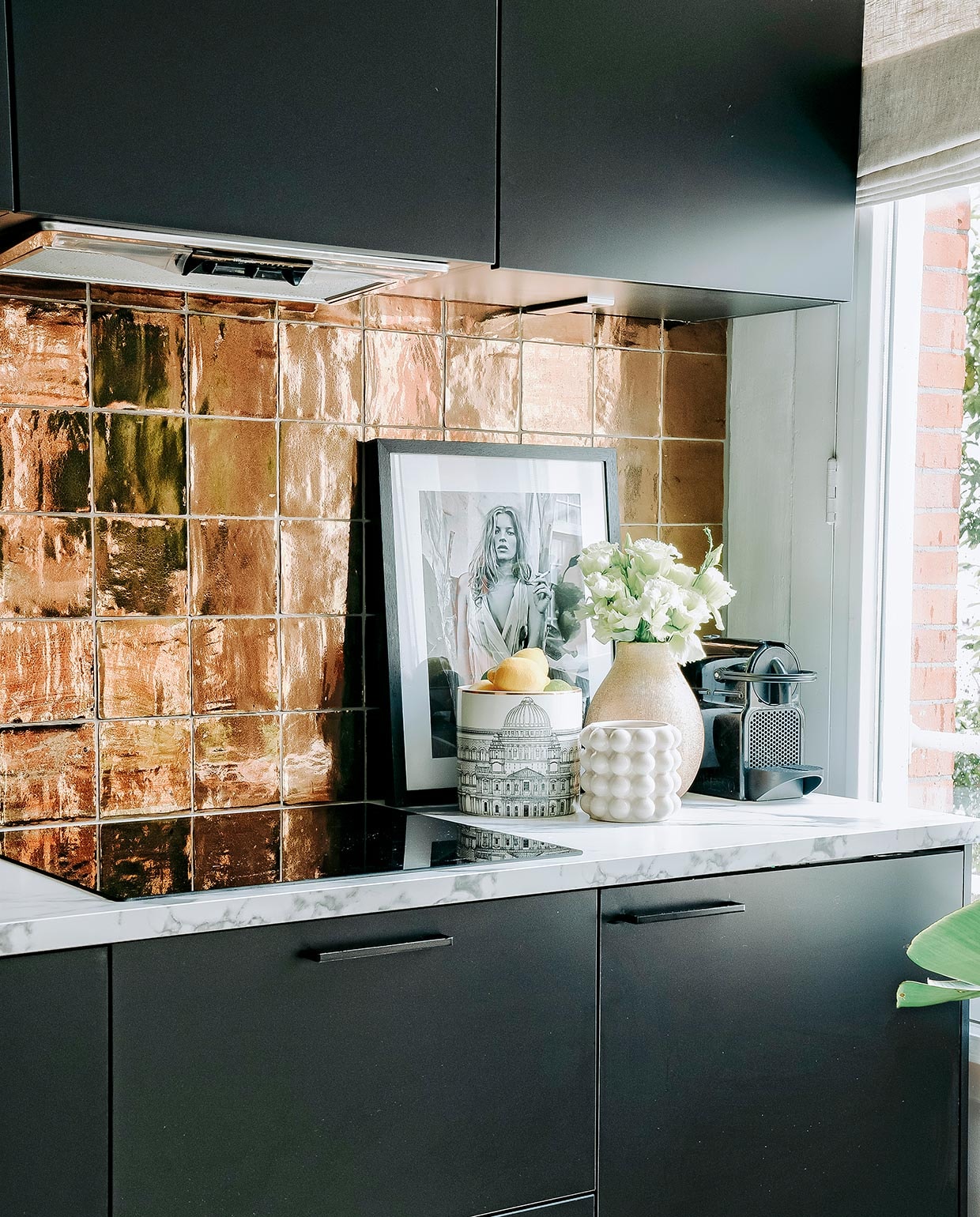 Keuken, marmeren werkblad en kraan Kooloos Interieurbouw. Tegels Megadump Tegels en Sanitair, vloer Nijhof. Zeeppompje en vaas Zara Home. Poef, kussen en schilderij Nox Studio Interiors. Plantenpot en plant Intratuin. Witte potten H&amp;M Home.